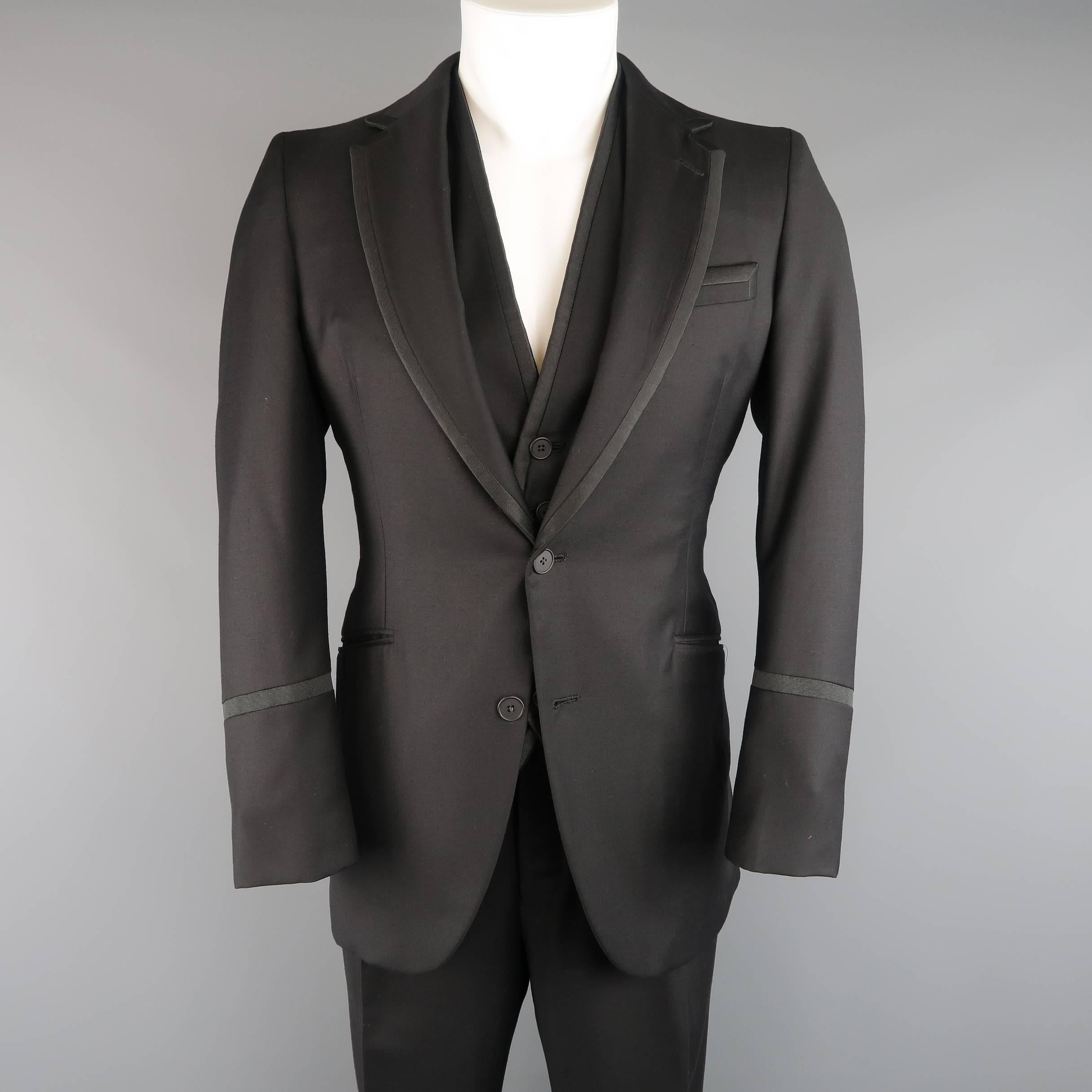 BOTTEGA VENETA three piece tuxedo suit comes in black wool twill with satin faille piping and includes a two button, notch lapel sport coat, v neck vest, and matching single pleat trousers. Made in Italy.
 
Good Pre-Owned Condition.
Marked: IT 50
