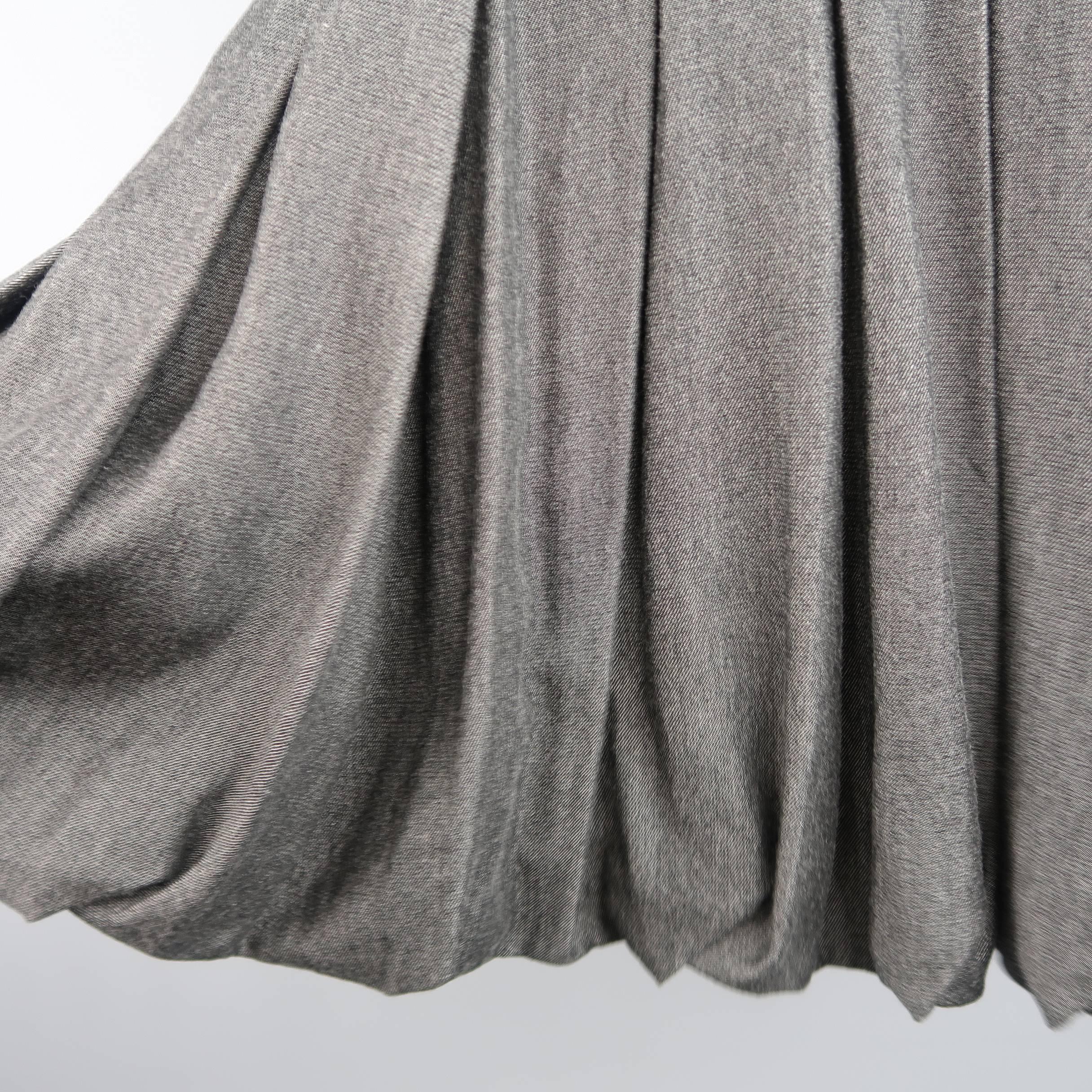 AKRIS A line skirt comes in gray bamboo fabric and features a box pleated construction, black waistband, and gathered bubble hemline. Made in Switzerland.
 
Excellent Pre-Owned Condition.
Marked: 4
 
Measurements:
 
Waist: 28 in.
Hip: 40 in.
Length: