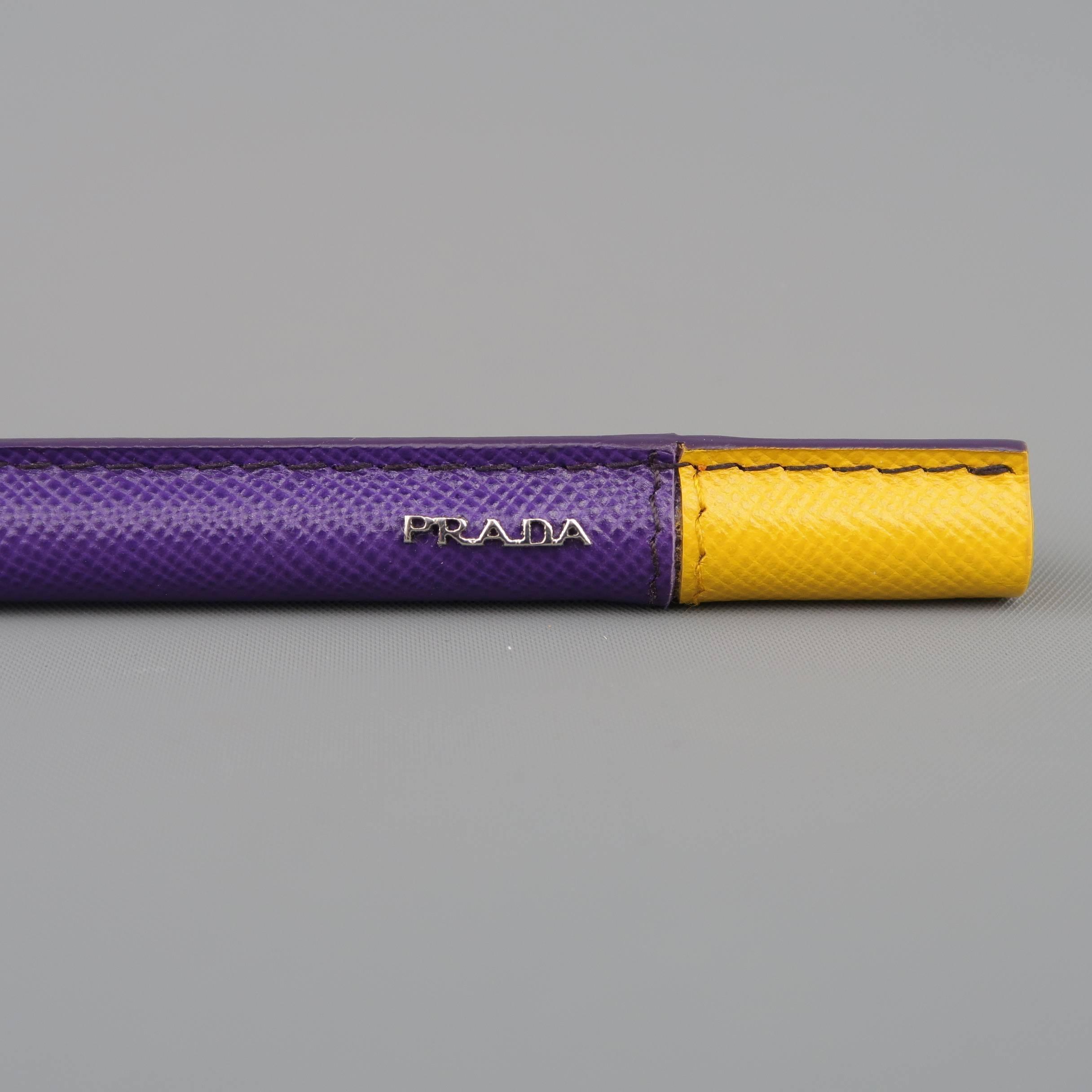 PRADA blue ink pen comes in purple and yellow textured leather and features a silver tone metal cap and logo. Small imperfection. As is. With box and extra ink.
 
Good Pre-Owned Condition.
 
6 in. x 1 cm.
SKU: 85385