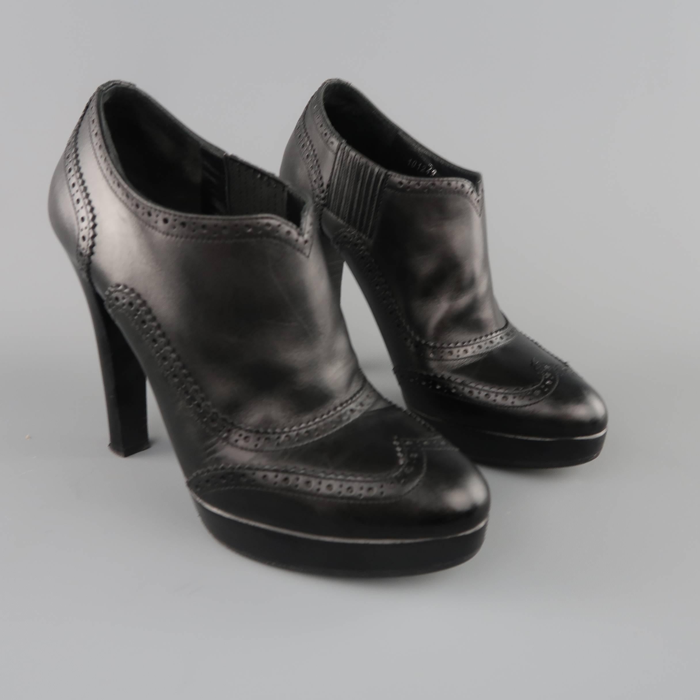 RALPH LAUREN COLLECTION platform booties come in smooth black leather and feature a rounded point toe, stacked heel and platform, and perforated wingtip details throughout. Made in Italy.
 
Good Pre-Owned Condition.
Marked: 7.5 B
 
Measurements:

