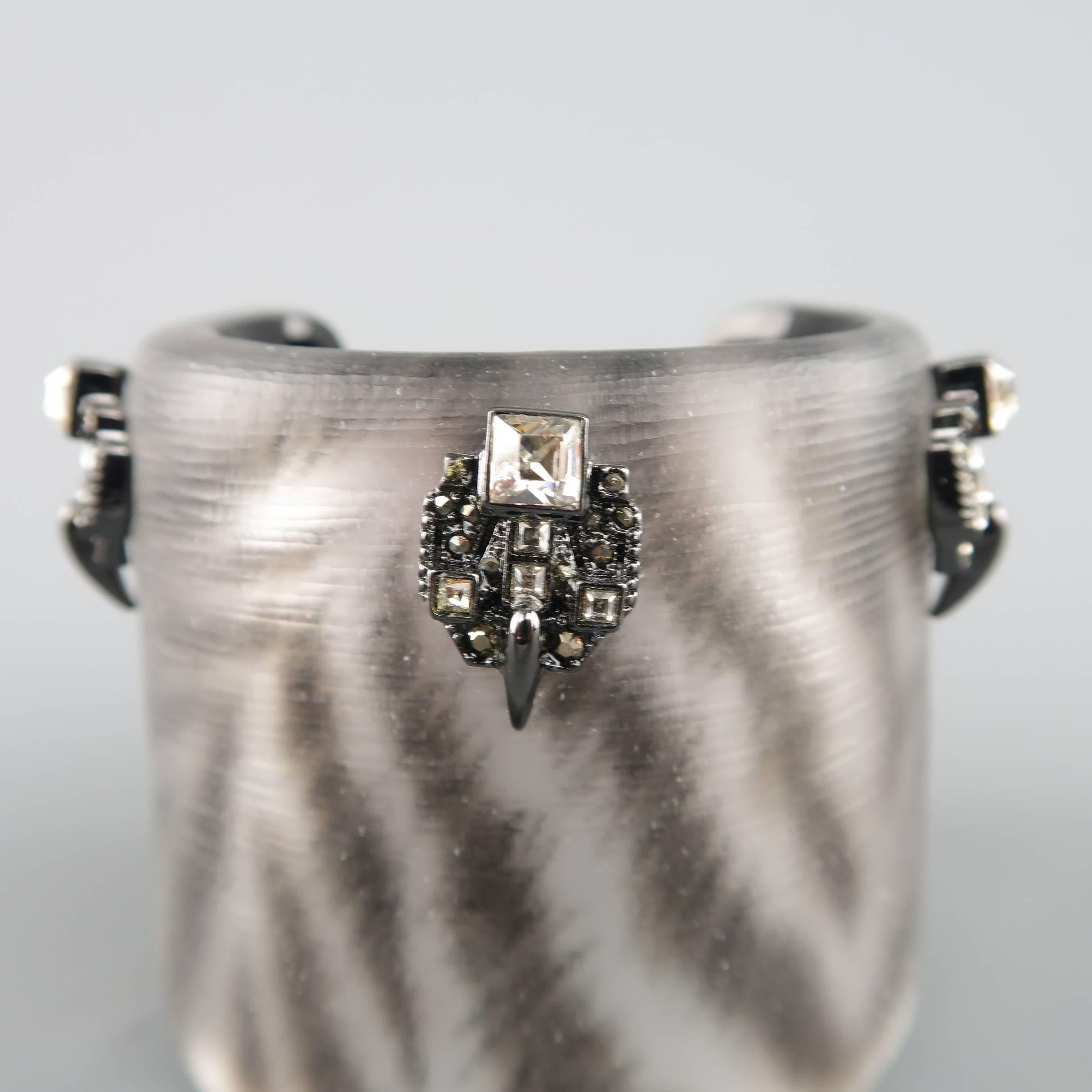 This gorgeous Alexis Bittar cuff bracelet from the Santa Fe Deco collection comes in silver metallic zebra print lucite with rhinestone crystal studded gunmetal adornments. Made in USA.
 
Excellent Pre-Owned Condition.
 
Length: 2.5 in.
Fits: 6.5
