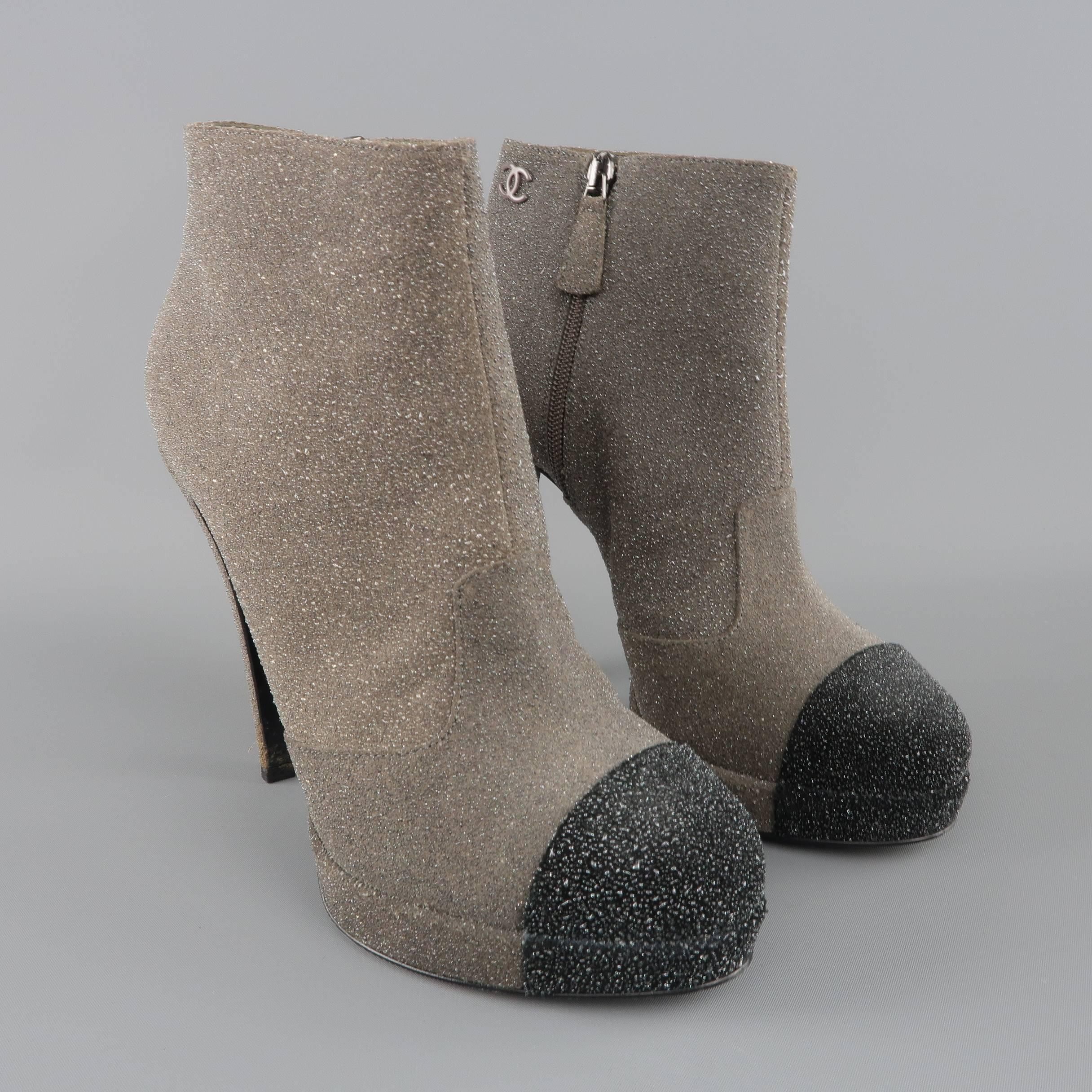 CHANEL ankle booties come in a unique sparkle encrusted taupe suede and feature a black toe cap, covered platform, structural stiletto heel, and CC logo. Made in Italy.
 
Good Pre-Owned Condition.
Marked: IT 38.5
 
Measurements:
 
Heel: 5.25