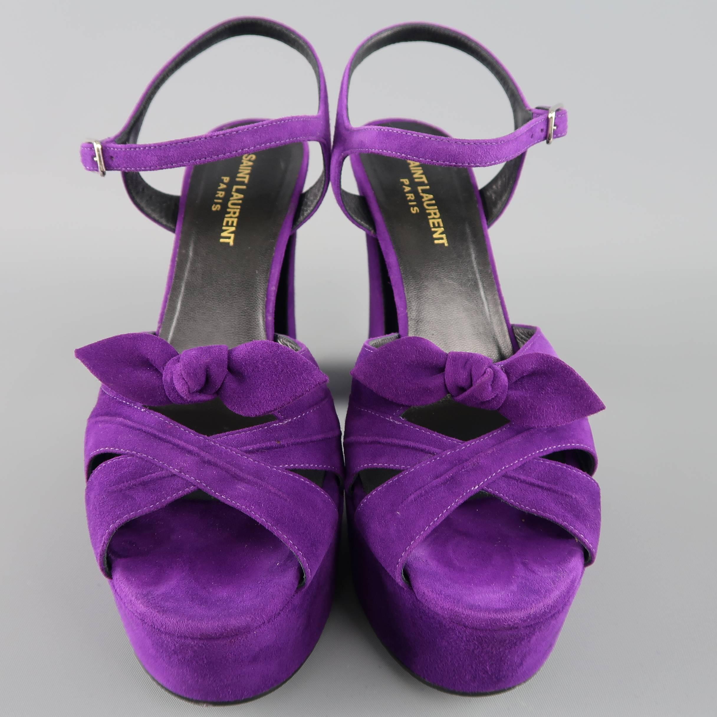 SAINT LAURENT "Candy" sandals come in bold purple suede and feature a thick crossed toe strap with bow, ankle harness, and chunky retro platform. Made in Italy.
 
Excellent Pre-Owned Condition.
Marked: IT 38.5
 
Measurements:
 
Heel: 5.10