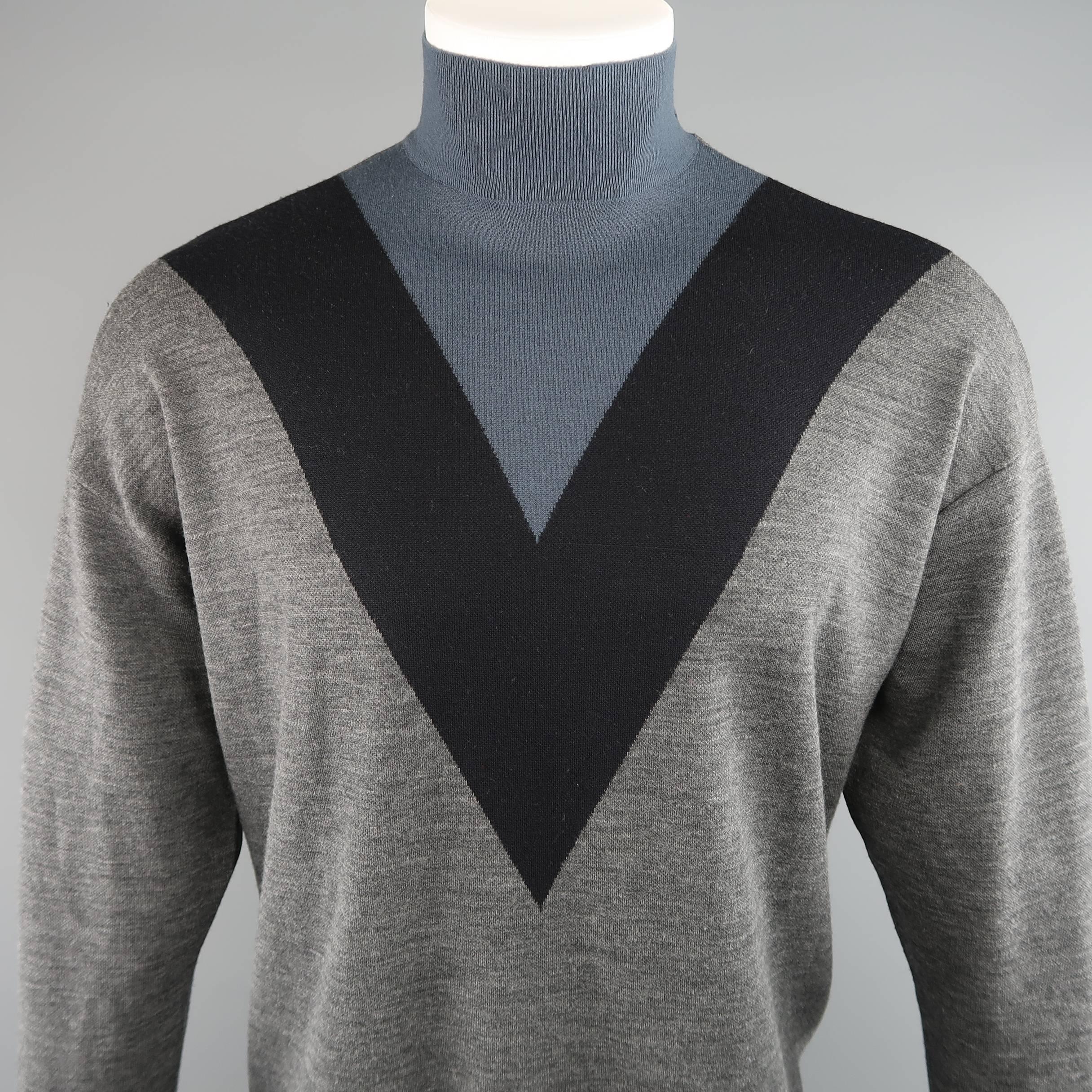 Oversized drop shoulder mock turtleneck by PRADA comes in heather gray wool knit with a black and teal blue V color block pattern. Made in Italy.
 
Good Pre-Owned Condition.
Marked: IT 50
 
Measurements:
 
Shoulder: 25 in.
Chest: 52 in.
Sleeve: 23.5