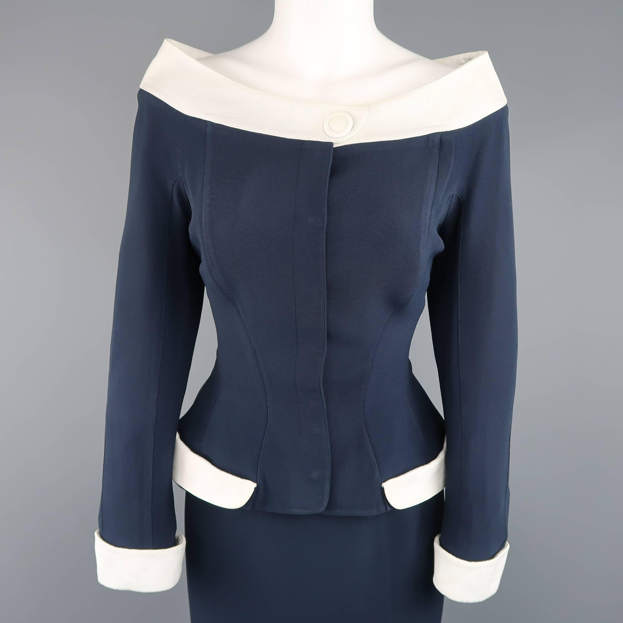 This fabulous early 1990's THIERRY MUGLER suit comes in a structured navy fabric and includes a cropped, cinched waist jacket with off the shoulder portrait collar and white trim and cuffs with a matching pencil skirt. Wear throughout and