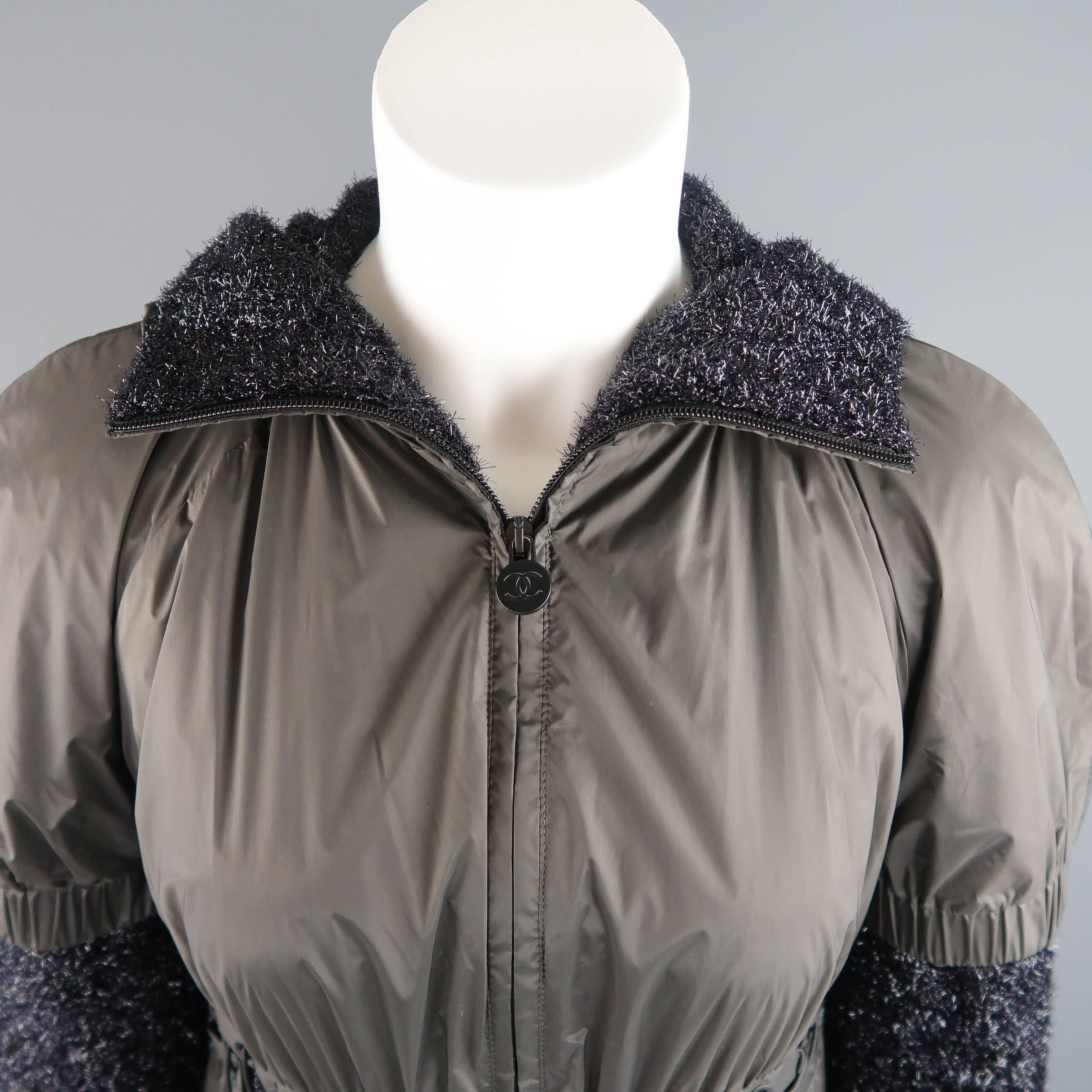 This fabulous CHANEL hooded jacket features a short, puffed sleeve charcoal windbreaker layer with lace up waistband over a textured black lurex tinsel knit long sleeved layer. Made in Italy.

Retails: $3,400.00.

New with Tags. 
Marked: FR 36
