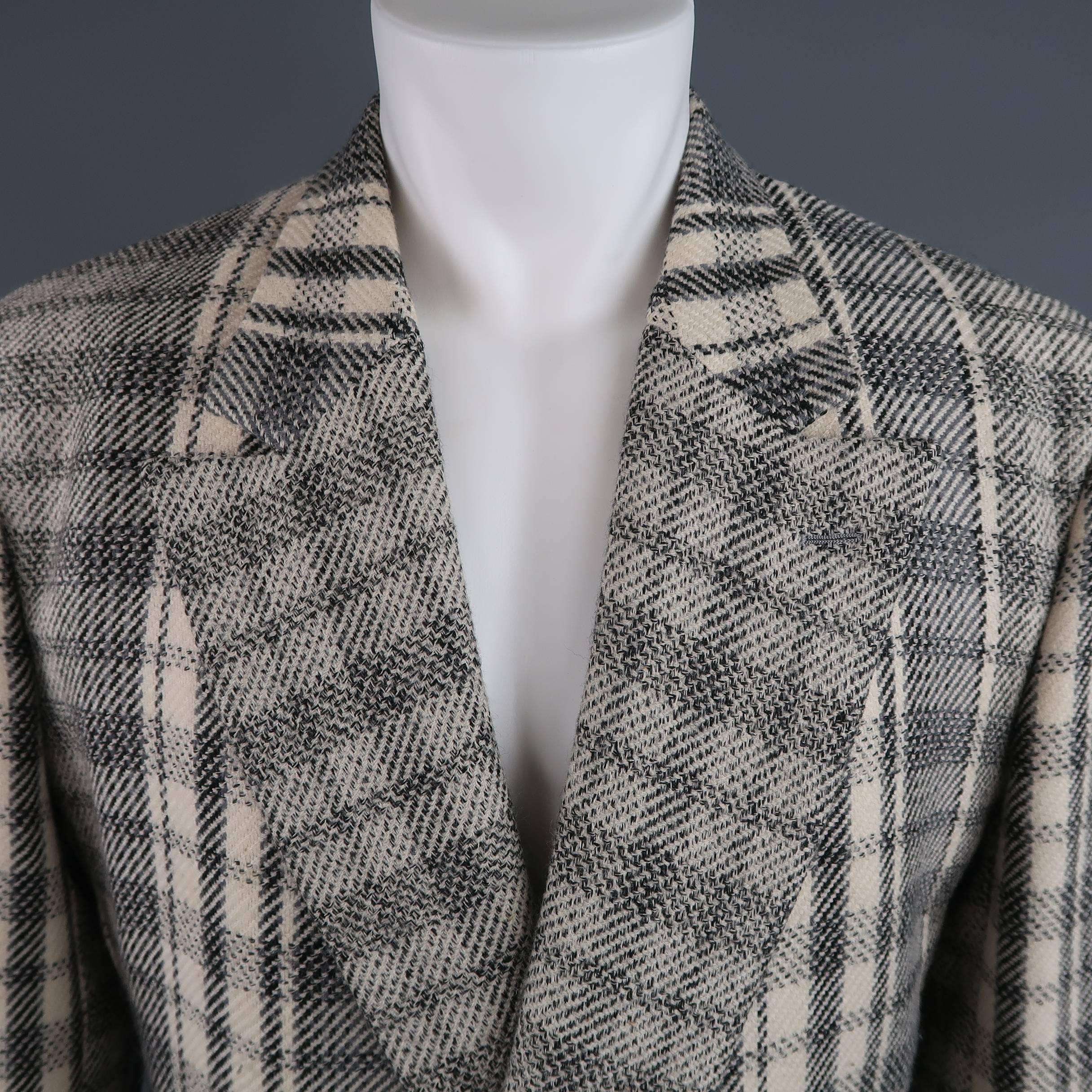 This vintage 1980's GIANNI VERSACE sport coat comes in a beige and gray plaid wool blend material and features a wide peak lapel, double breasted front with dark gold tone, leather detailed buttons, patch pockets, and functional button cuffs. Wear