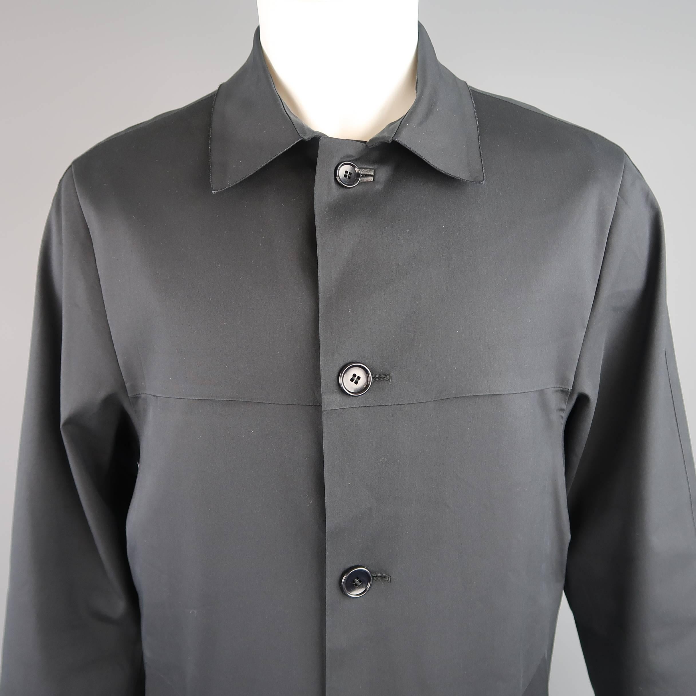 Modern classic LOUIS VUITTON car coat comes in a deep midnight navy coated cotton and features a pointed collar with raw edge, chest slits, button up front, slanted pockets, silver tone embossed studs at back collar, and Damier satin and cotton