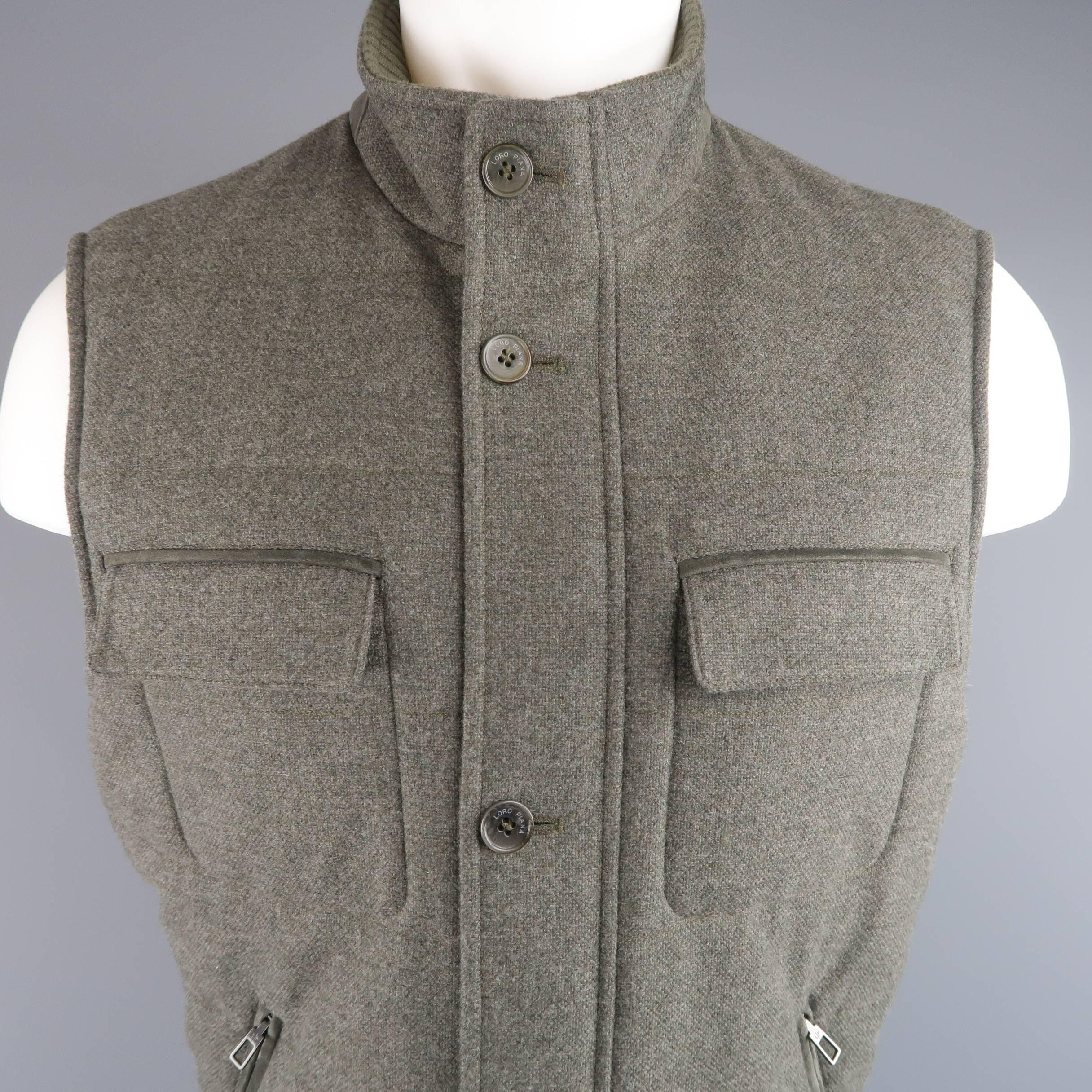 LORO PIANA quilted vest comes in a slate heather gray wool cashmere blend knit and features a high neck with ribbed liner, zip front with button over placket, slanted zip pockets with suede piping, and flap breast pockets. Made in Italy.
 
Excellent