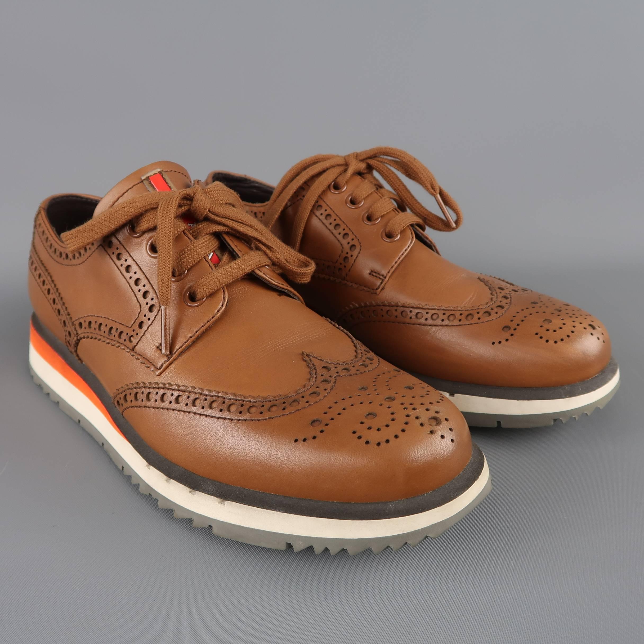 PRADA lace ups come in a rich tan leather with a rounded wingtip toe, red logo tongue, perforated brogue details throughout, and orange and white athletic platform sole. Wear throughout. As-is.
 
Fair Pre-Owned Condition.
Marked: UK 6
 
Outsole: