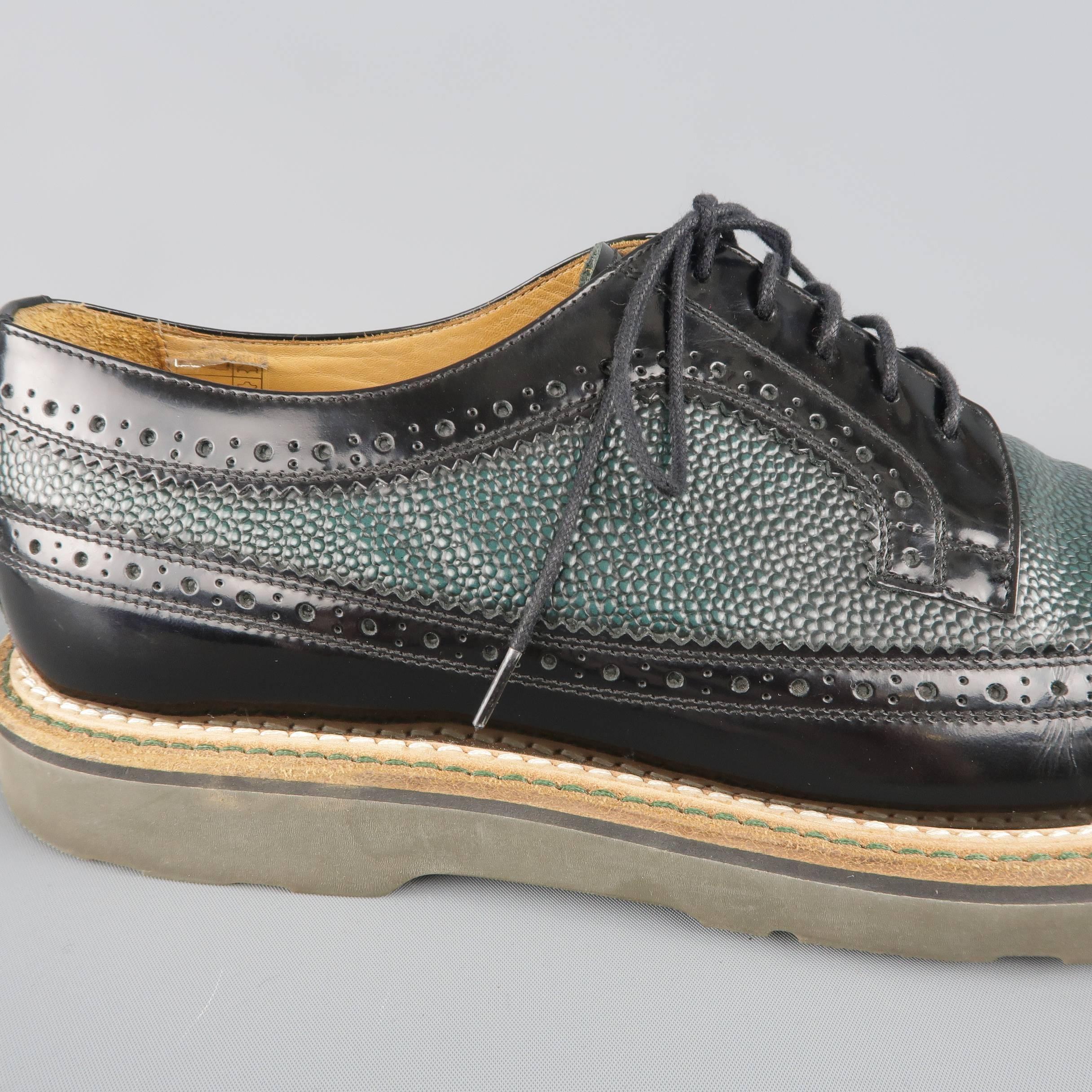 PAUL SMITH lace up dress shoes come in black patent leather with a forest green pebbled leather mid panel and feature a rounded point wingtip toe, perforated brogue details throughout, and leather and robber sole. Made in Italy.
 
Good Pre-Owned