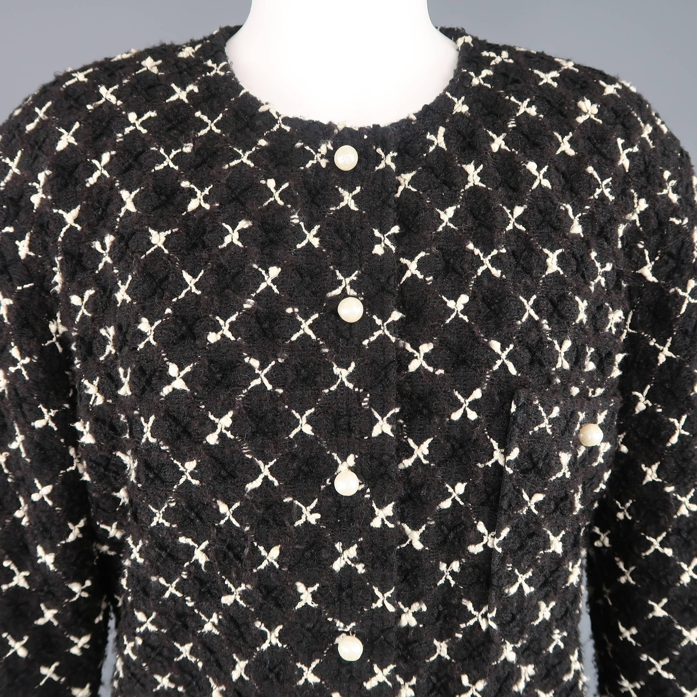 Vintage 1980's CHANEL jacket comes in a black and creamy beige X cross pattern tweed and features a round, collarless neckline, triple patch pocket front, and button up closure with pearl buttons. Minor wear throughout. Made in France.
 
Good