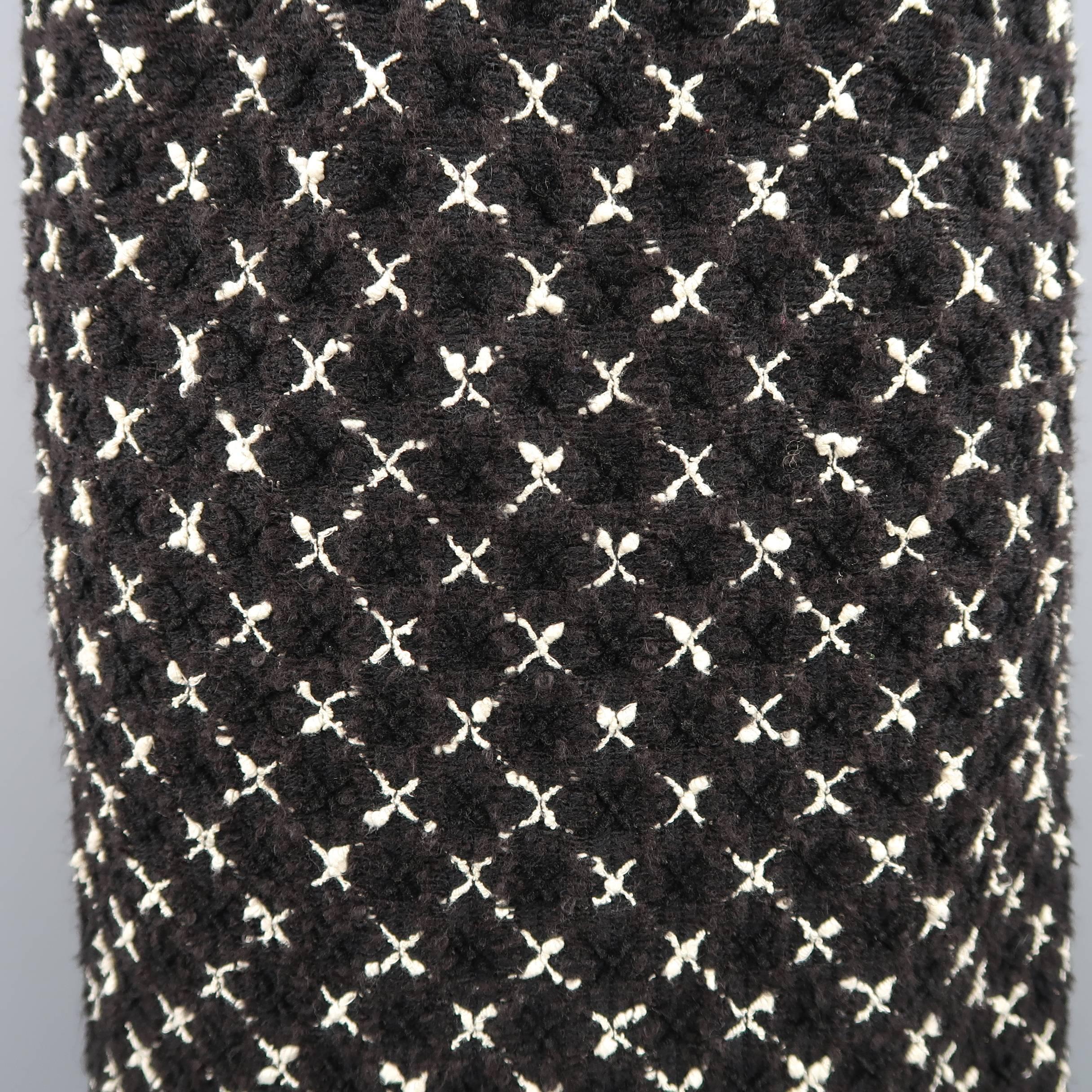 Vintage 1980's CHANEL A-line pencil skirt comes in a black and cream X cross print boucle tweed with a back zip closure and satin liner. Wear around zipper. Altered to fit a size small. As-Is. Made in France.
 
Fair Pre-Owned Condition.
Marked: FR