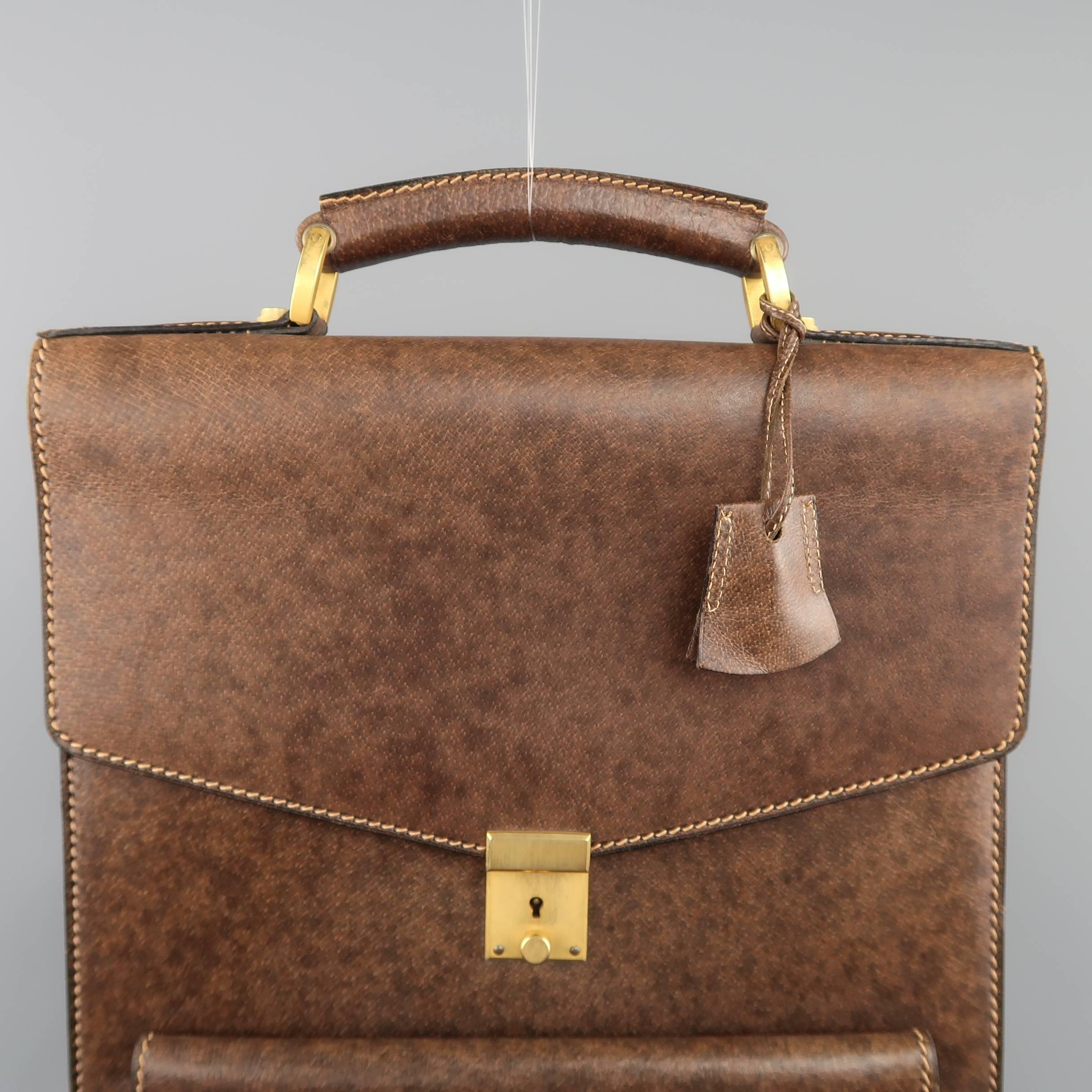 Vintage GUCCI briefcase comes in a brown marbled look leather and features a long, rectangular shaped accordion construction, frontal envelope pocket, double carry straps at the bottom, flap top closure with gold tone lock, covered top handle with