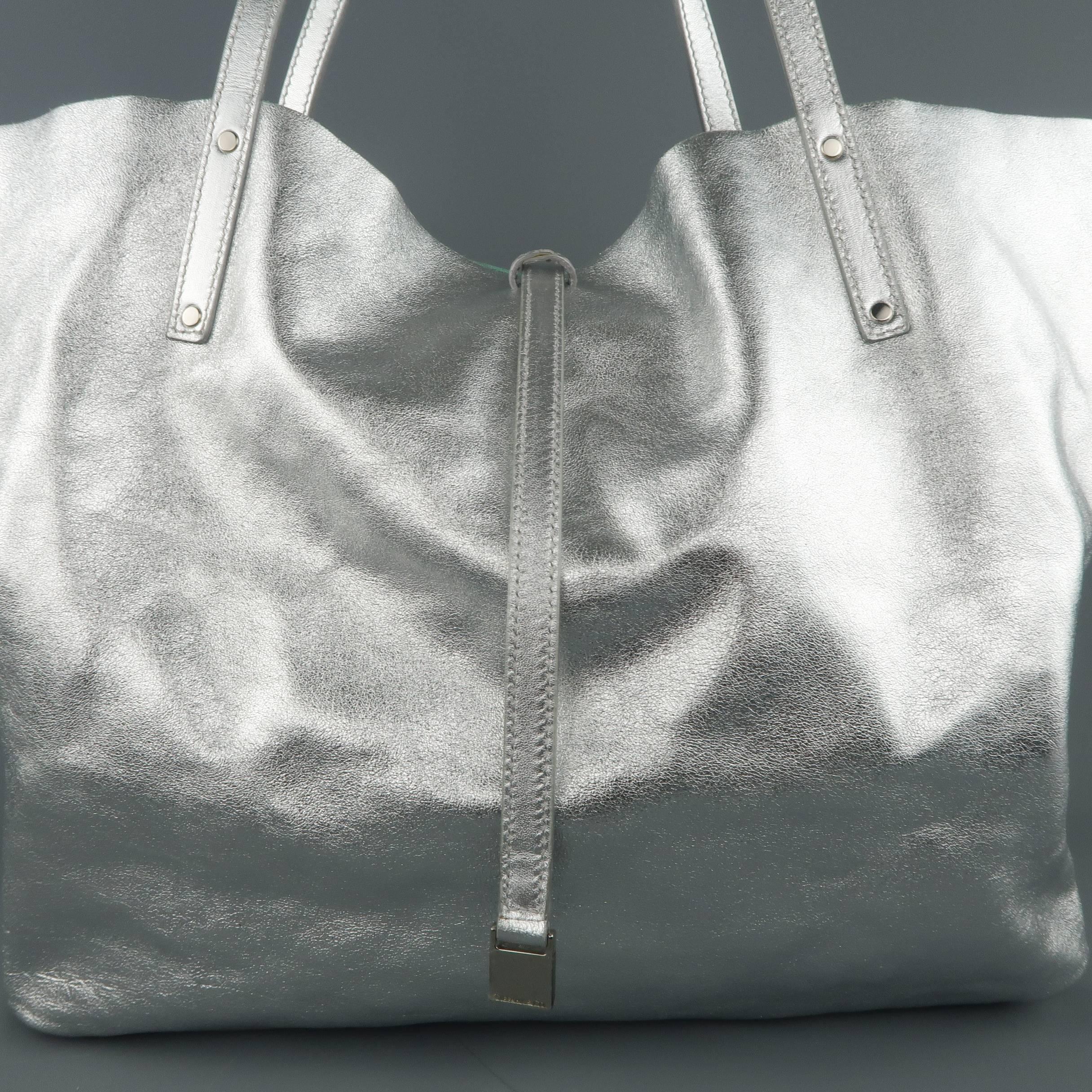 TIFFANY & CO. shopper tote bag comes in a metallic textured silver leather with double top handles, enamel logo hardware, and pull through top closure with reverse 