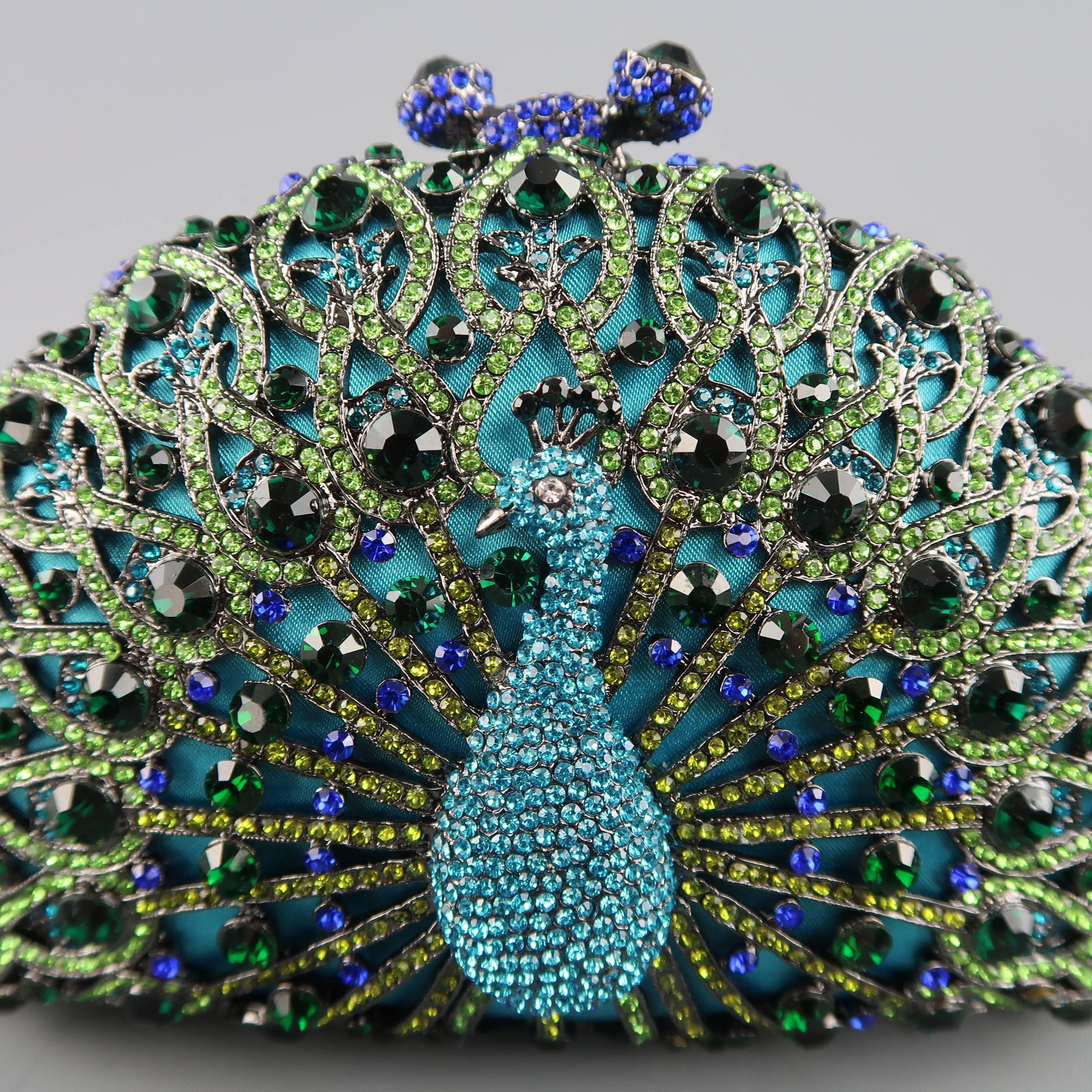 LUXMOB evening clutch comes in turquoise satin with allover metal, rhinestone encrusted peacock motif, magnetic faux kiss lock closure, and optional shoulder strap.
 
New with Tags.
 
Measurements:
 
Length: 6.5 in.
Width: 2 in.
Height: 4 in.
Drop:
