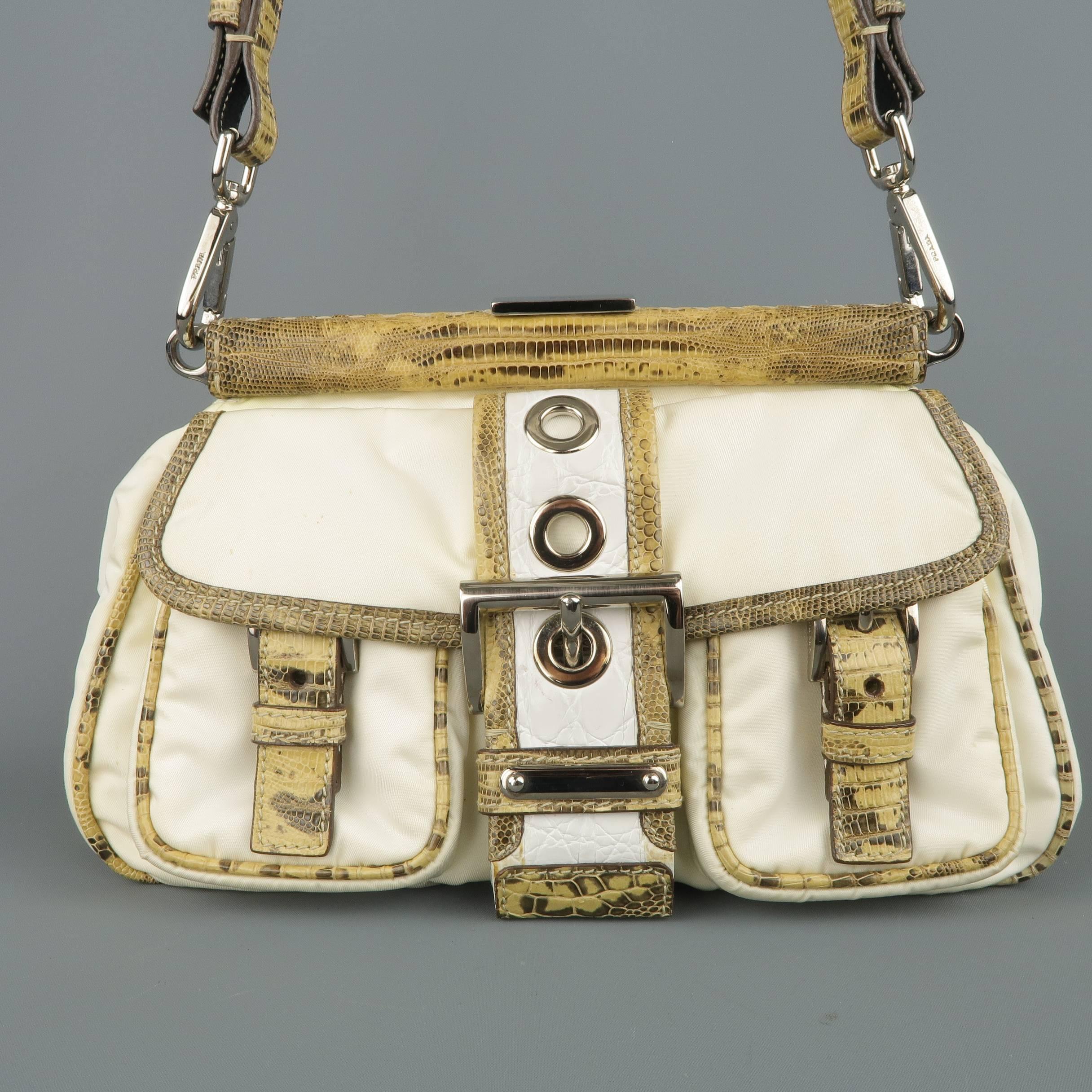 PRADA mini shoulder bag comes in cream nylon and features a hinge closure, frontal pockets, lizard skin leather piping and shoulder strap, and frontal white crocodile embossed leather grommet belt with buckle. Discoloration and wear throughout