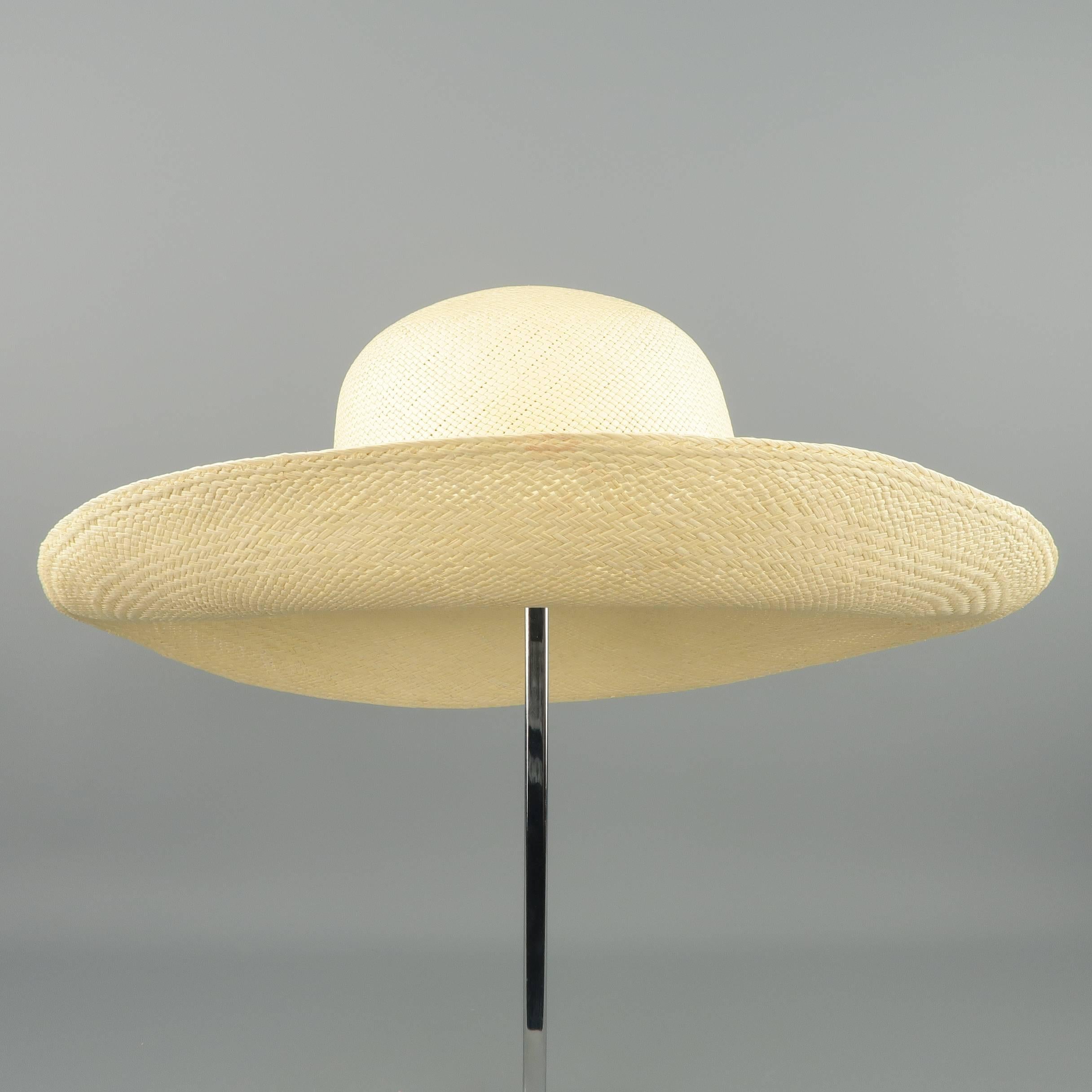 Vintage sun hat in light beige woven straw with a semi wide brim.
Good Pre-Owned Condition.
 
Measurements:
    Opening: 7 x 7.5 in.
    Brim: 4 in.
    Height: 4 in.