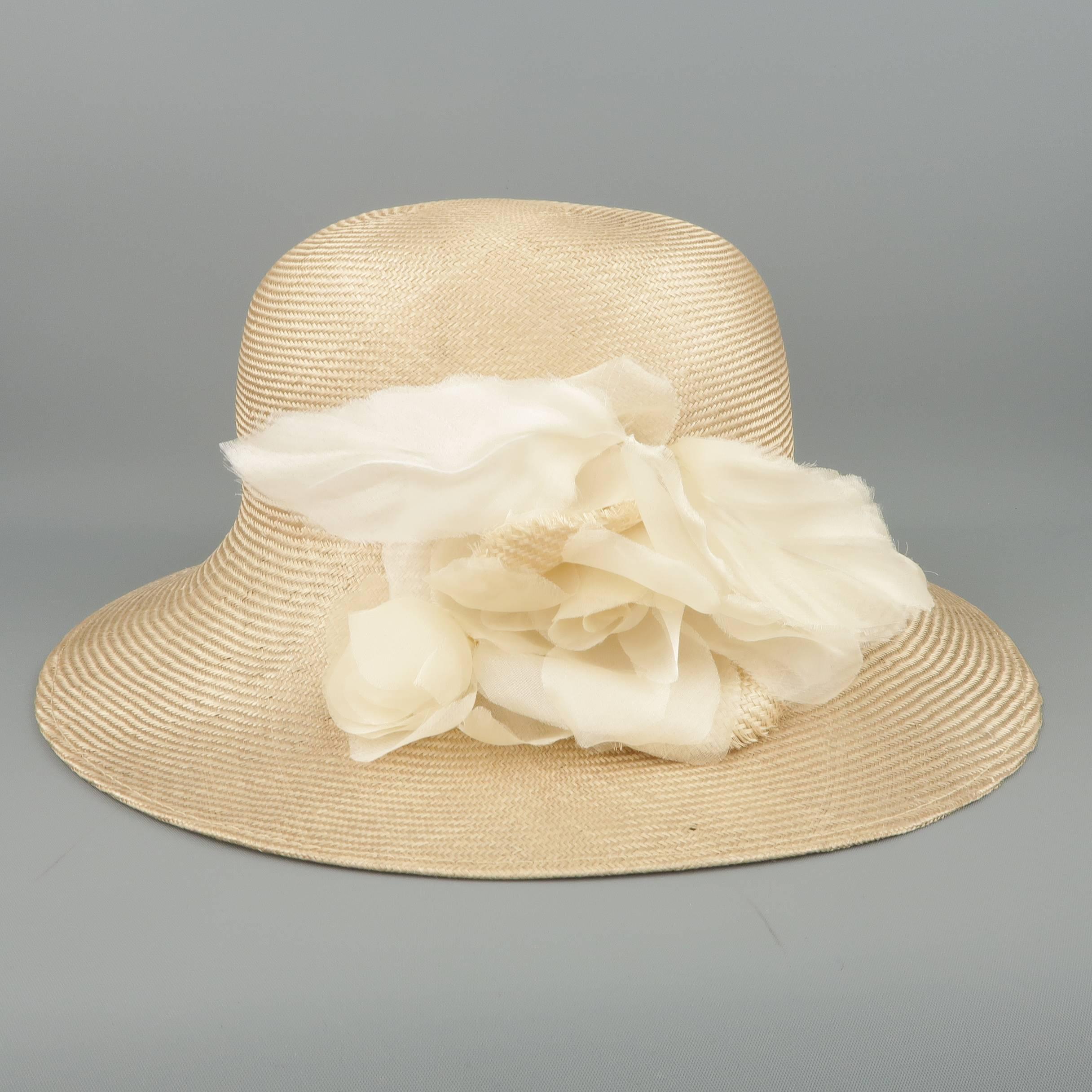 GABRIELA LIGENZA sun hat comes in a shiny blonde beige woven straw and features cream silk organza flower and leaf appliques. Wear throughout including small hole on brim and wear on lining. As-is. Includes a hat box.  Made in Italy.
 
Good