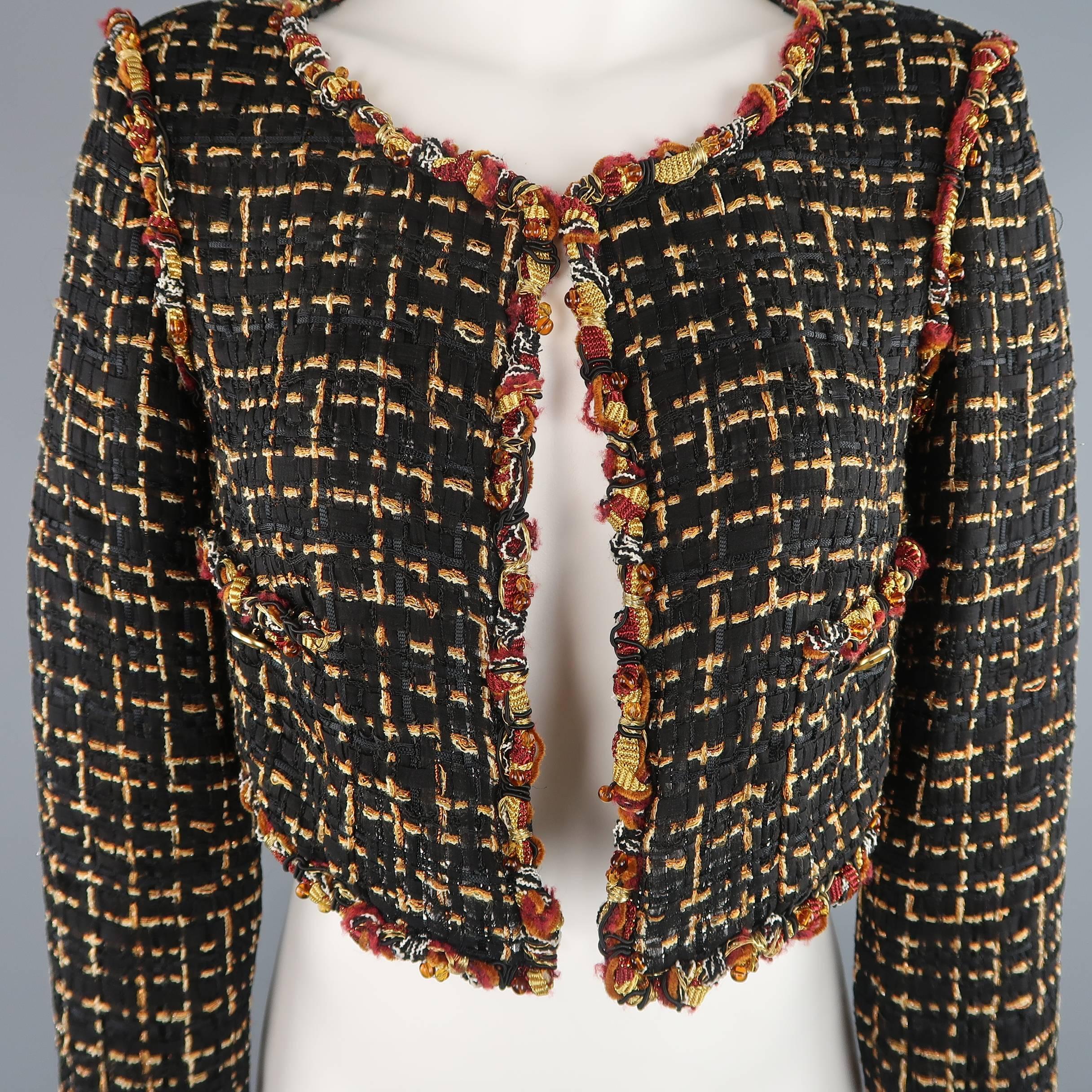 This fabulous cropped CHANEL jacket comes in a light weight black and gold silk blend woven Lesage and features a round neckline with single hook eye closure, double faux pockets with gold enamel buttons, three quarter sleeves, and burgundy and