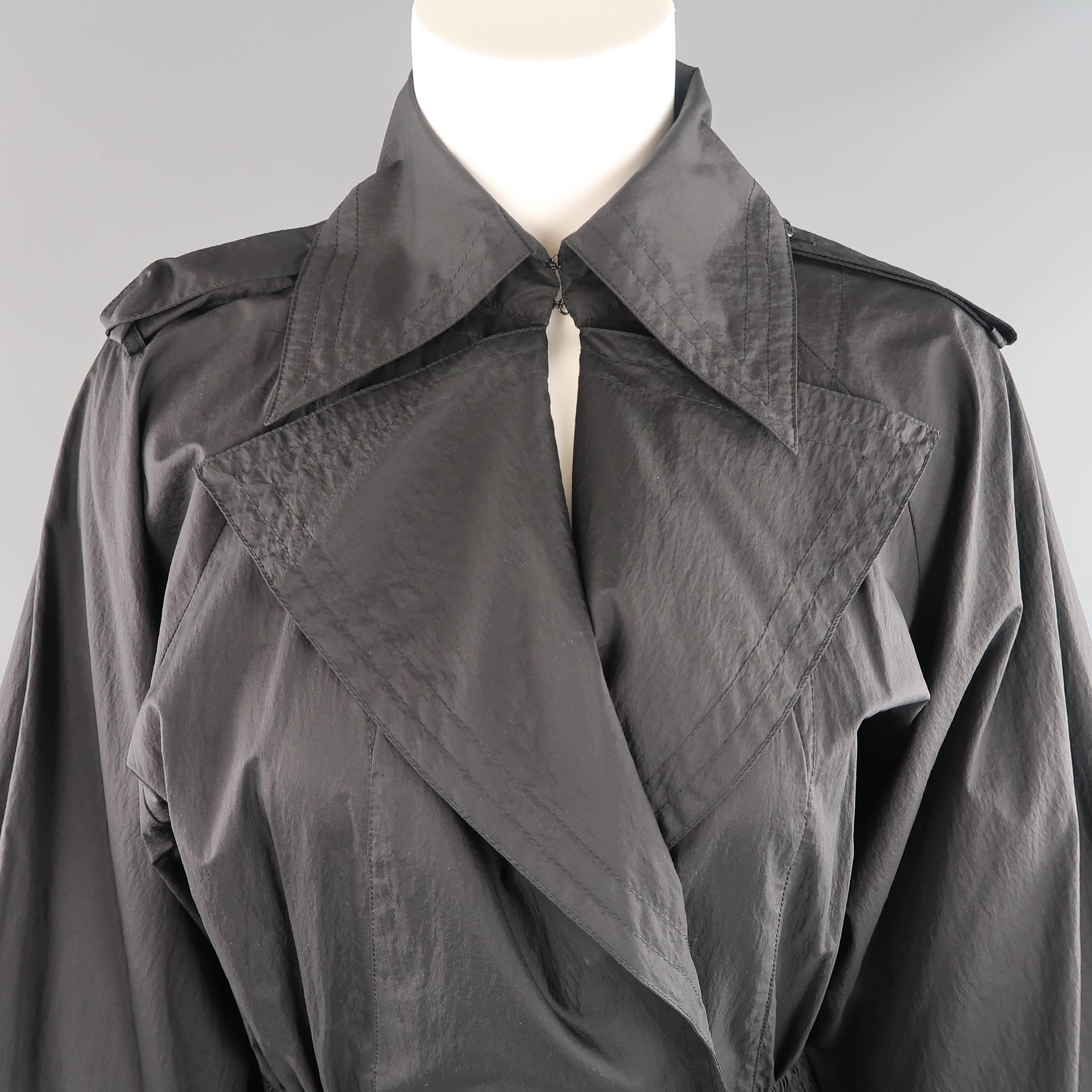 This fabulous CHANEL jacket comes in a light weight nylon windbreaker material and features a pointed collar with hook eye closures, pointed lapel, double breasted front with enamel flower buttons, epaulets, raglan balloon sleeves,  cinched, elastic