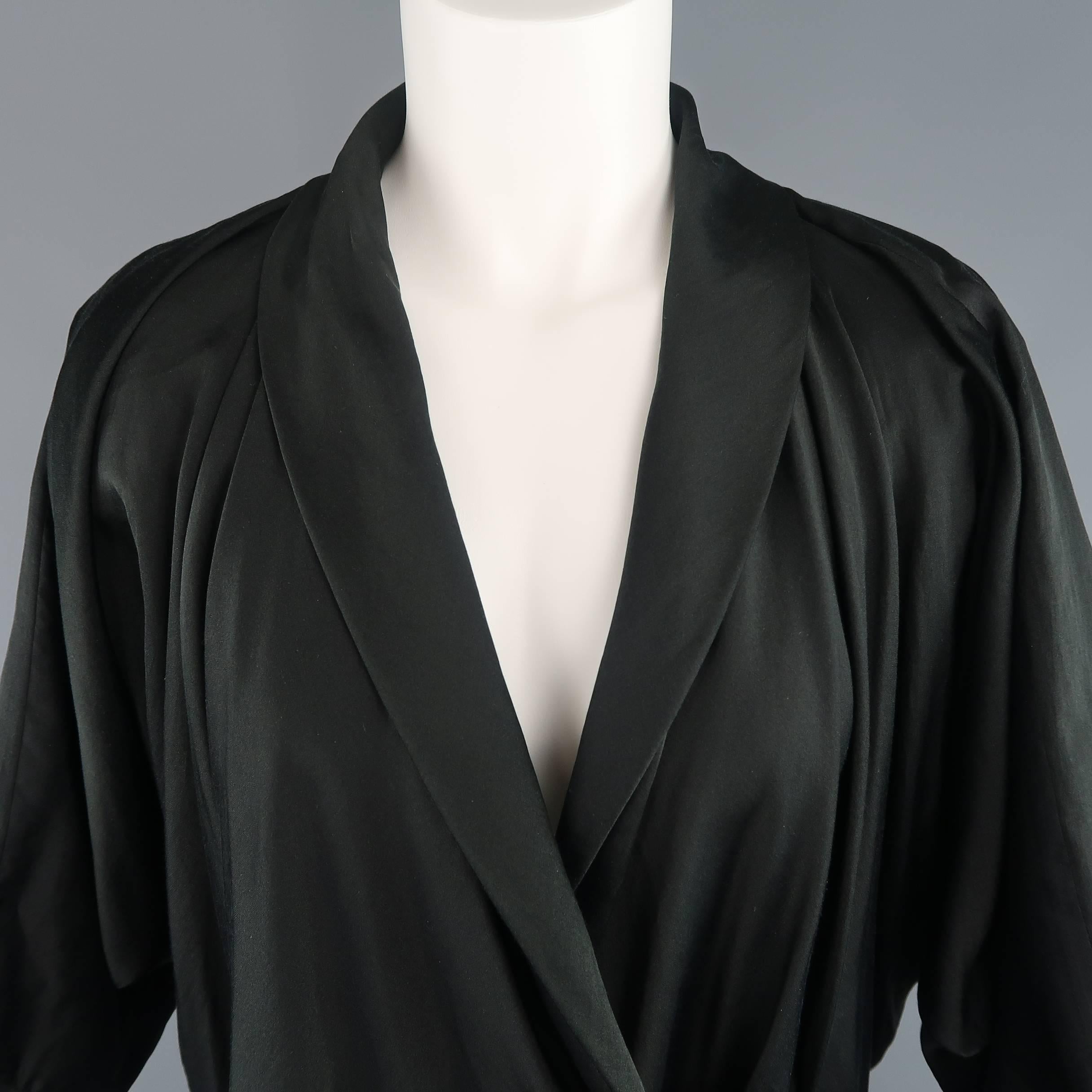 This LANVIN blouse comes in a light weight silk cotton blend sateen and features a tie and hook eye closure wrap front, shawl collar lapel, three quarter dolman sleeve with raw edge piping trim, and pleated drape shoulders. Made in France.
