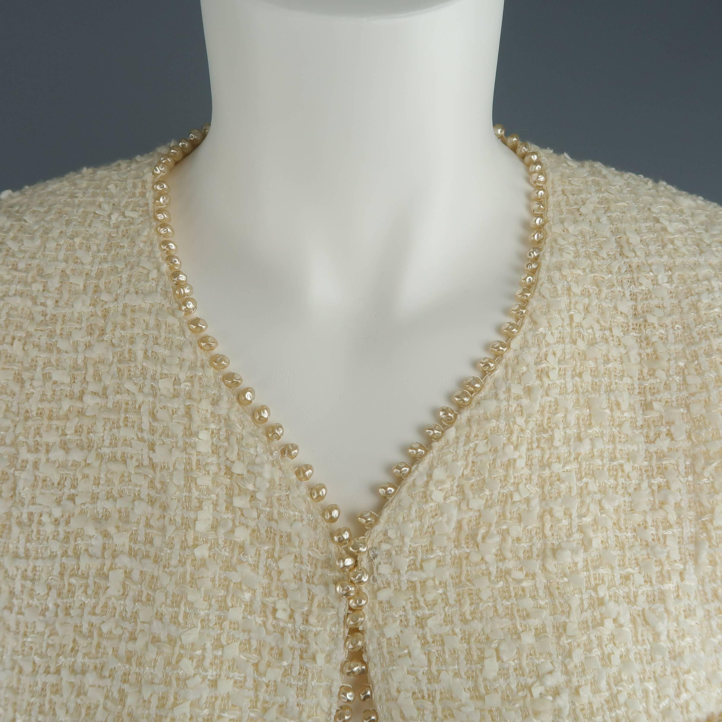 This fabulous archive Chanel jacket from Spring 1999 comes in a light weight creamy beige cotton blend Lesage tweed and features a collarless V neckline with single hook eye top closure, patch pockets, functional button cuffs (seam still intact),