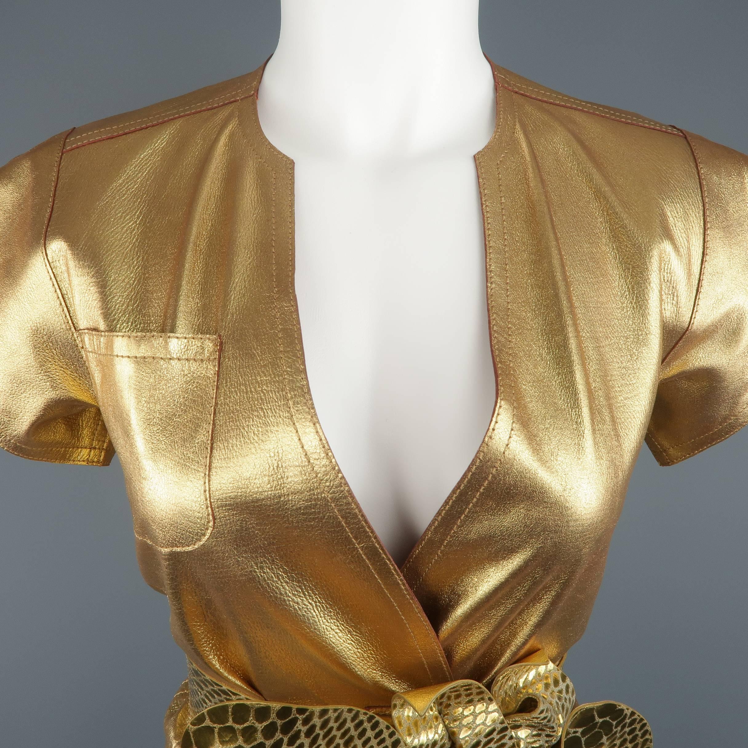 Marc Jacobs Spring 2011 runway top comes in metallic gold leather and features a deep V neck, wrap snap front, short sleeves, and crocodile textured waist belt with oversized flower. Made in USA.
 
Excellent Pre-Owned Condition.
Marked: 2
