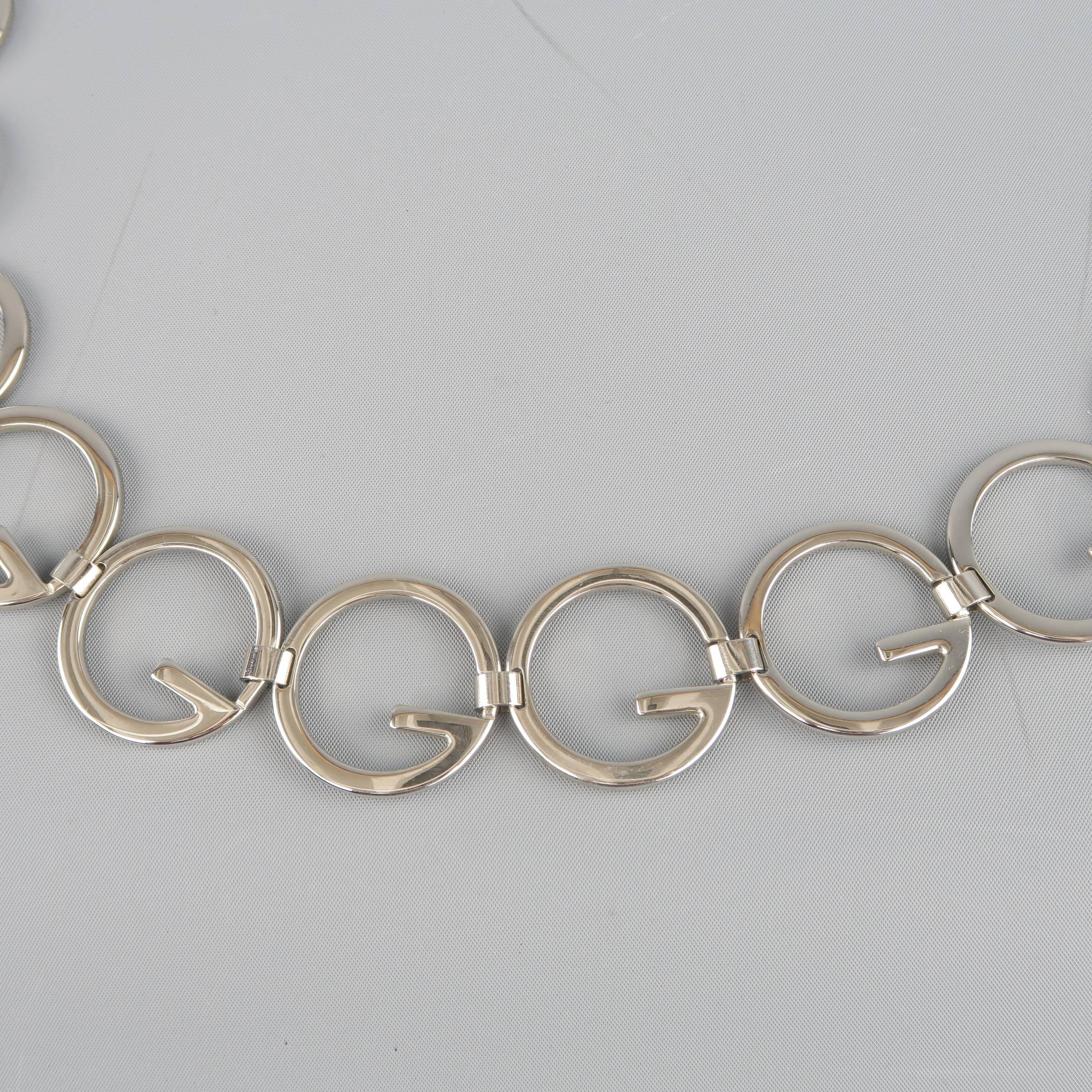 Vintage GUCCI chain belt  comes in silver tone polished metal and features Round G loops and chain clasp closure. Made in Italy.
 
Good Pre-Owned Condition.
Marked: (no size)
 
Length: 34.5 in.
Width: 1.45 in.
Fits: 30-34 in.
SKU: 87220 
Category: