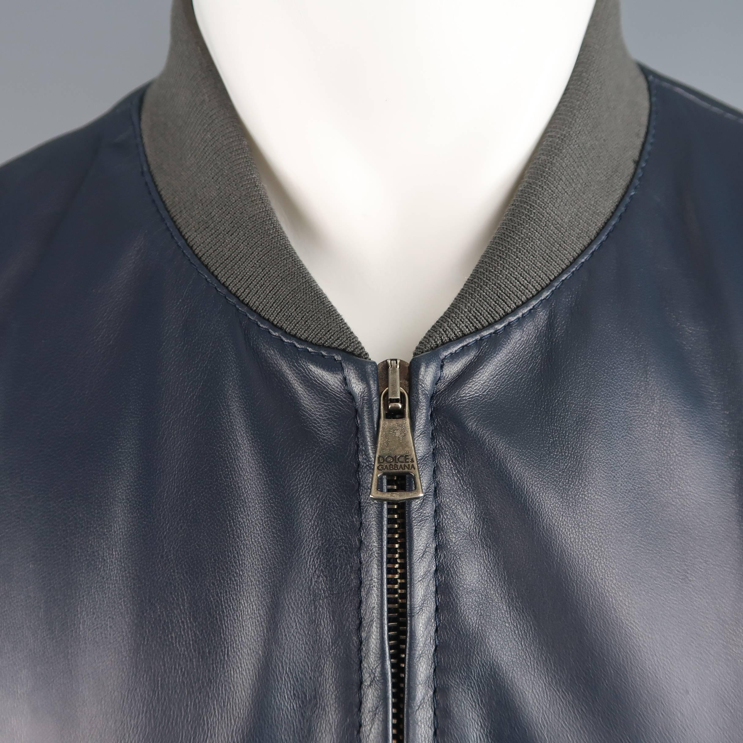 Tailored DOLCE & GABBANA bomber jacket comes in smooth navy blue leather with gray ribbed waistband, cuffs, and baseball collar and slanted snap pockets. Made in Italy.
 
Excellent Pre-Owned Condition.
Marked: IT 52
 
Measurements:
 
Shoulder: 18