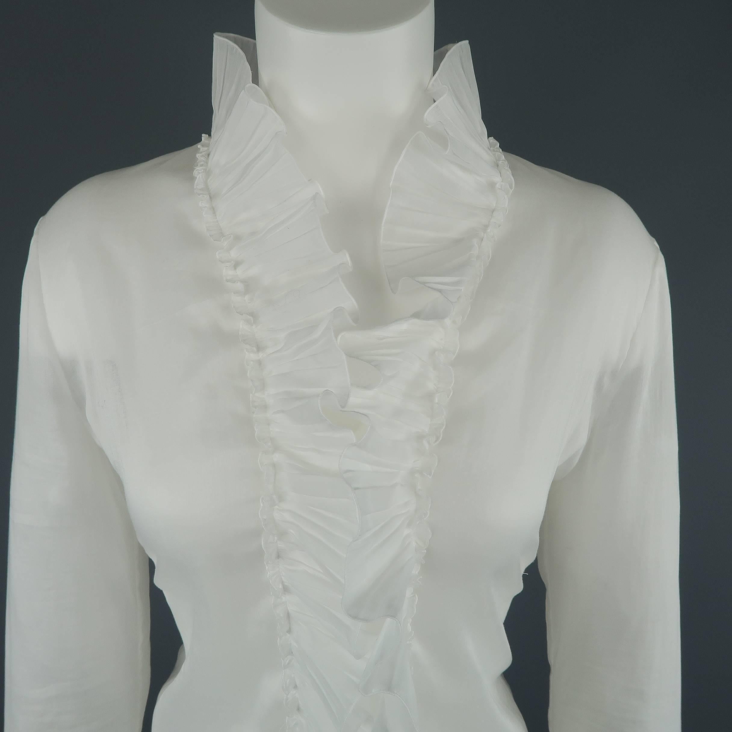ALEXANDER MCQUEEN blouse comes in a light weight, sheer cotton gauze and features a V neck line, four button front, curved hem, and pleated ruffle trim and cuffs. Label removed. Made in Italy.
 
Excellent Pre-Owned Condition.
Marked: (no size)
