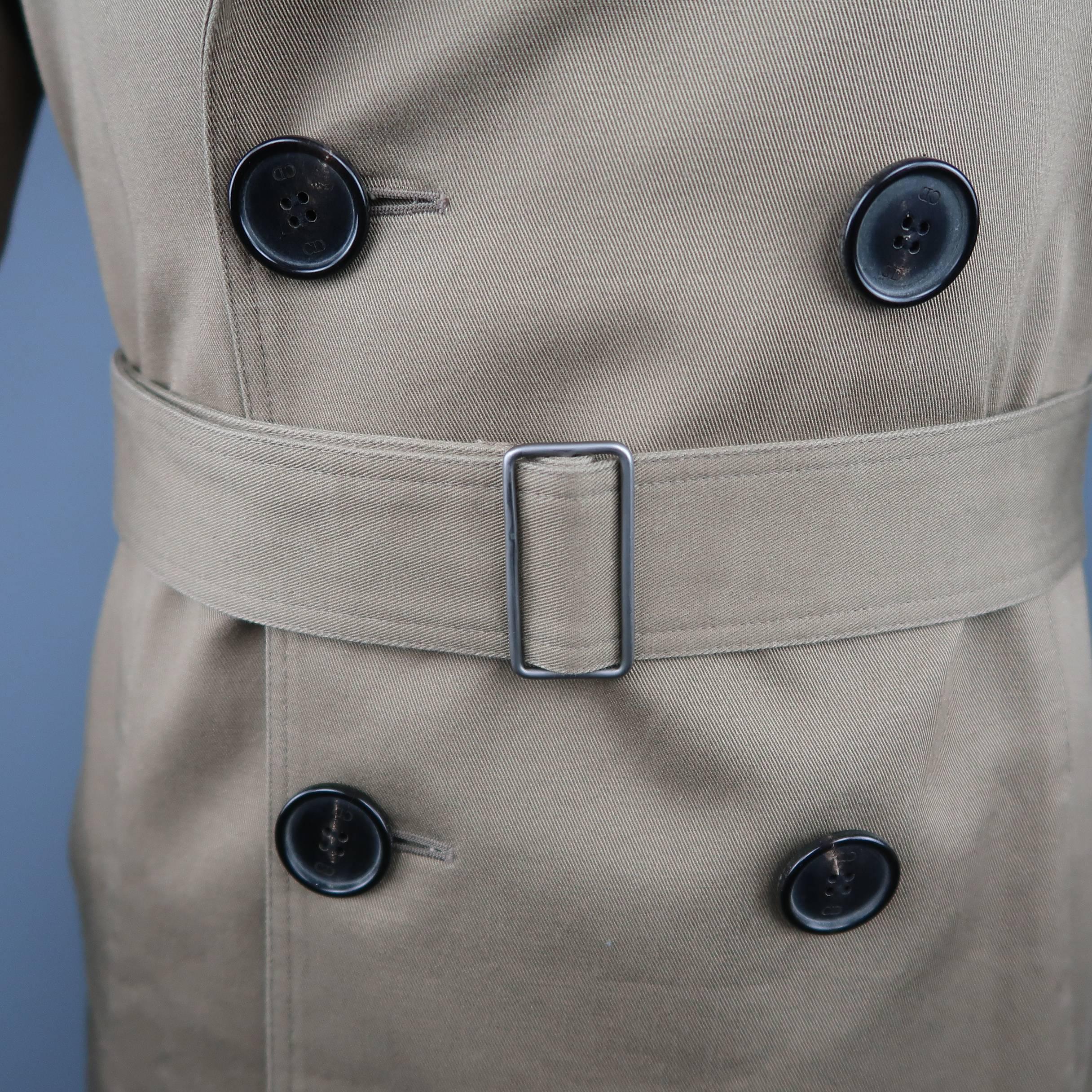 DIOR HOMME by Hedi Slimane comes in tan khaki cotton twill with a pointed lapel, double breasted button up front, slanted pockets, storm flap collar, epaulets, and optional waist belt. Made in Italy.
 
Excellent Pre-Owned Condition.
Marked: IT 48
