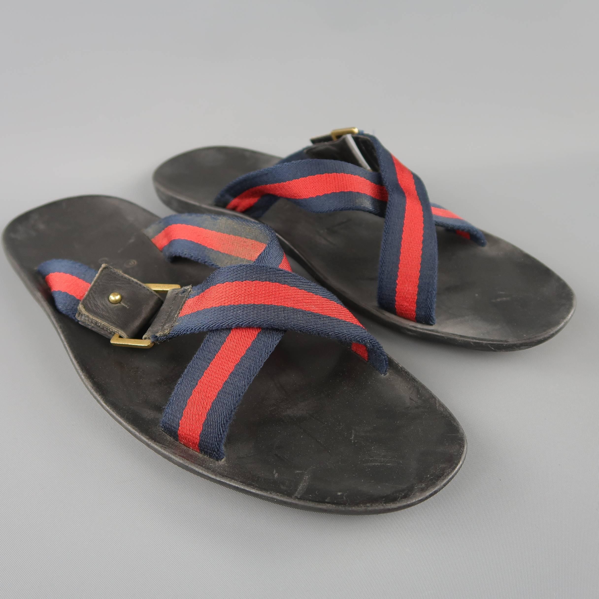 GUCCI sandals feature signature navy and red webbing canvas X straps with a leather detailed buckle and rubber sole. Heavy wear throughout. As-is. Made in Italy.
 
Fair Pre-Owned Condition.
Marked: (no size)
 
Outsole: 12 x 4.5 in.
