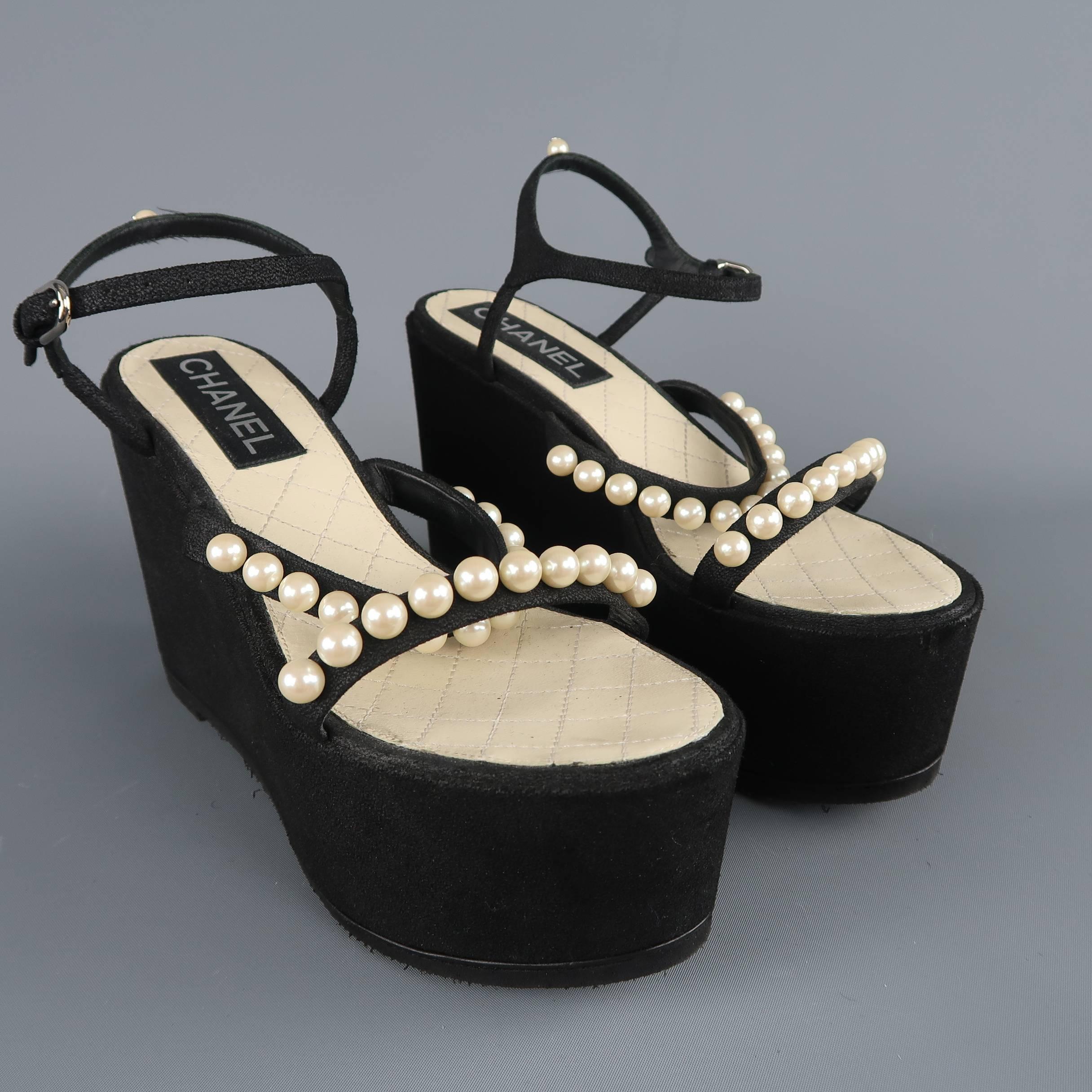 Chanel Spring 2014 sandals come in black suede and feature two toe straps with faux pearl embellishments, thick platform wedge sole, and ankle harness with CC pearl back. Vibram sole added. Made in Italy.
 
Excellent Pre-Owned Condition.
Marked: (no
