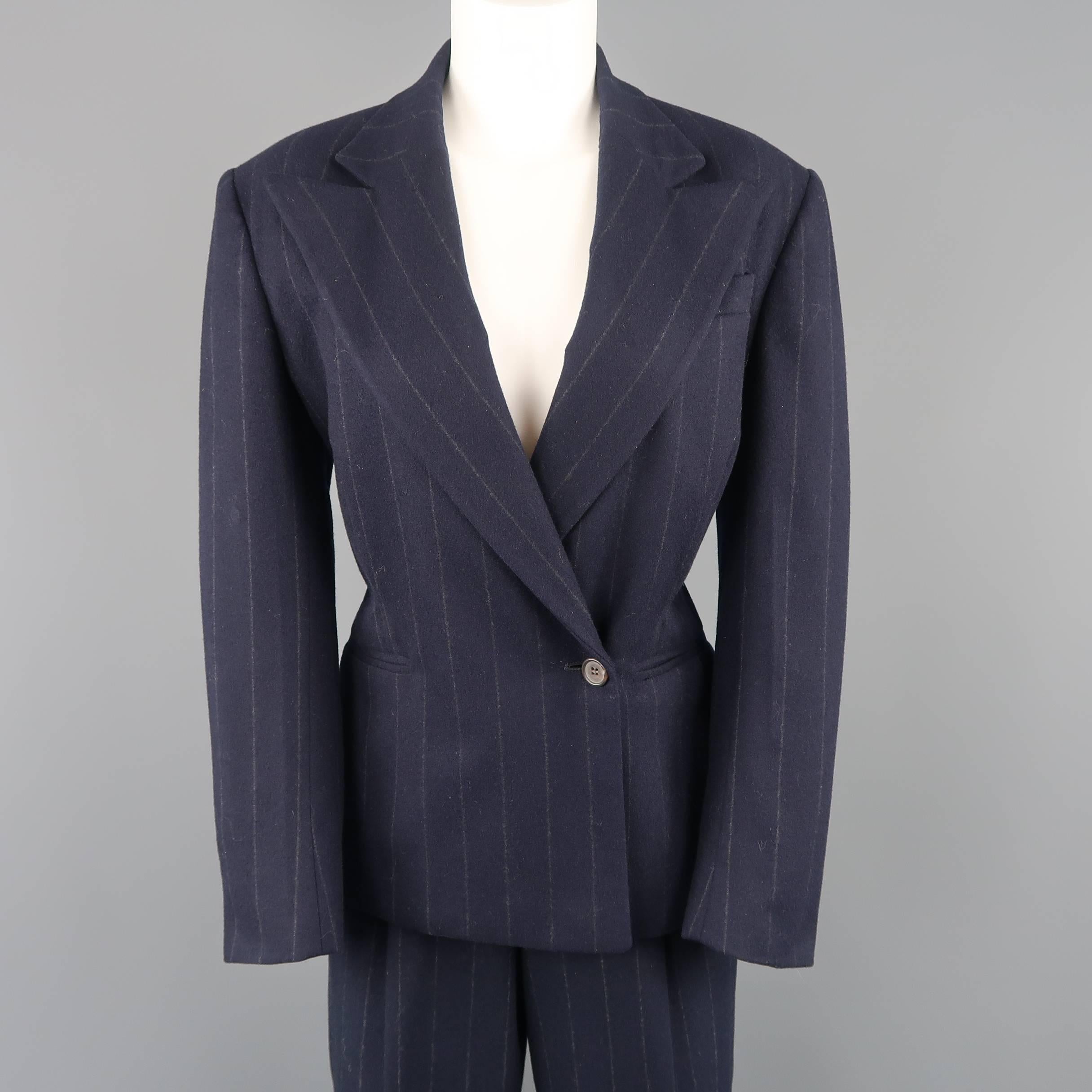 Ralph Lauren Collection suit comes in navy blue pinstripe wool and includes a tailored, single button, double breasted jacket with a peak lapel and pleated back and matching high rise, pleated, cuffed hem trousers. Made in USA.
 
Excellent Pre-Owned