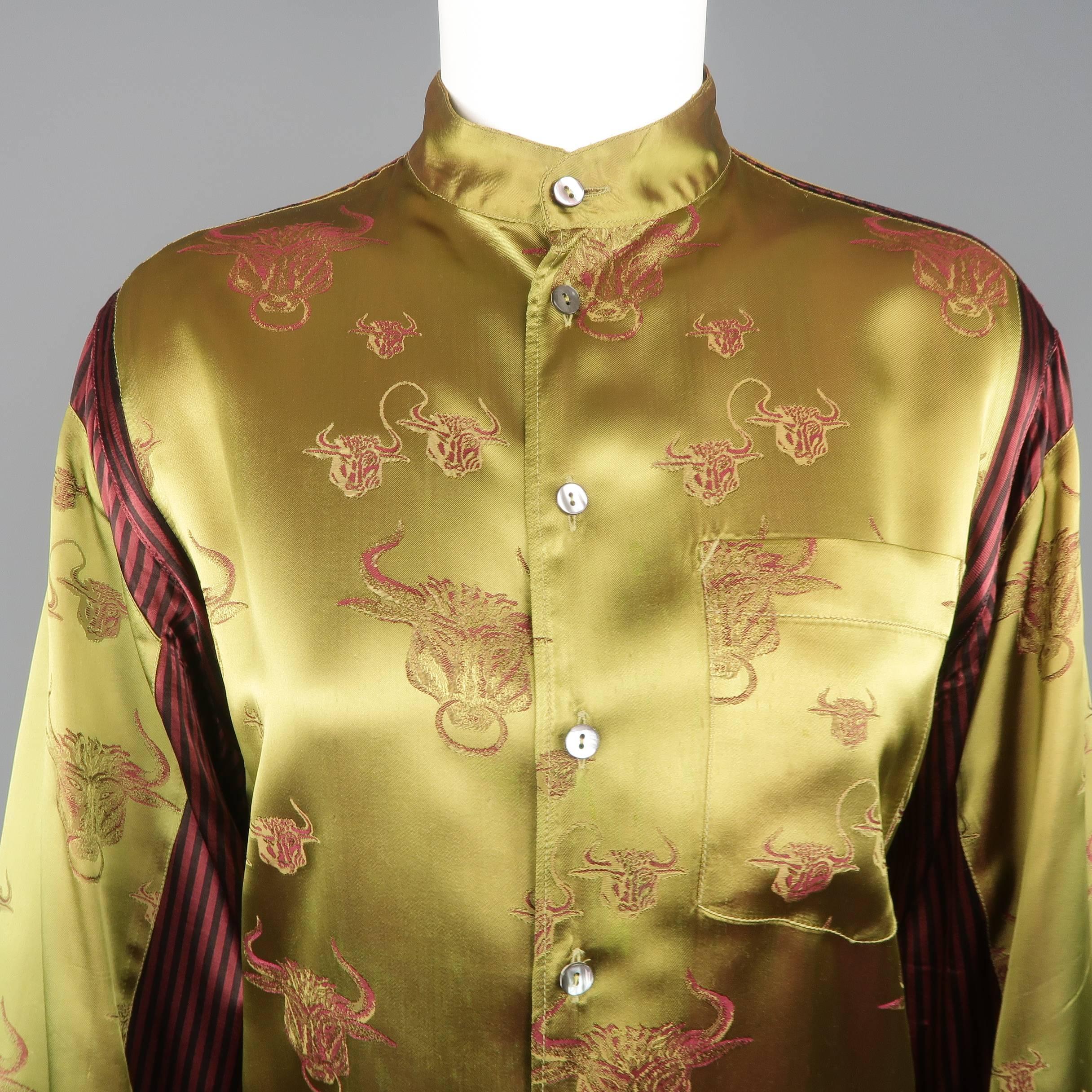 Vintage JEAN PAUL GAULTIER blouse jacket comes in green bull print damask satin and features a band collar, breast and side pockets, and red and black stripe panels. Wear throughout satin and discoloration thorough shoulder and sleeves. As-is.  Made