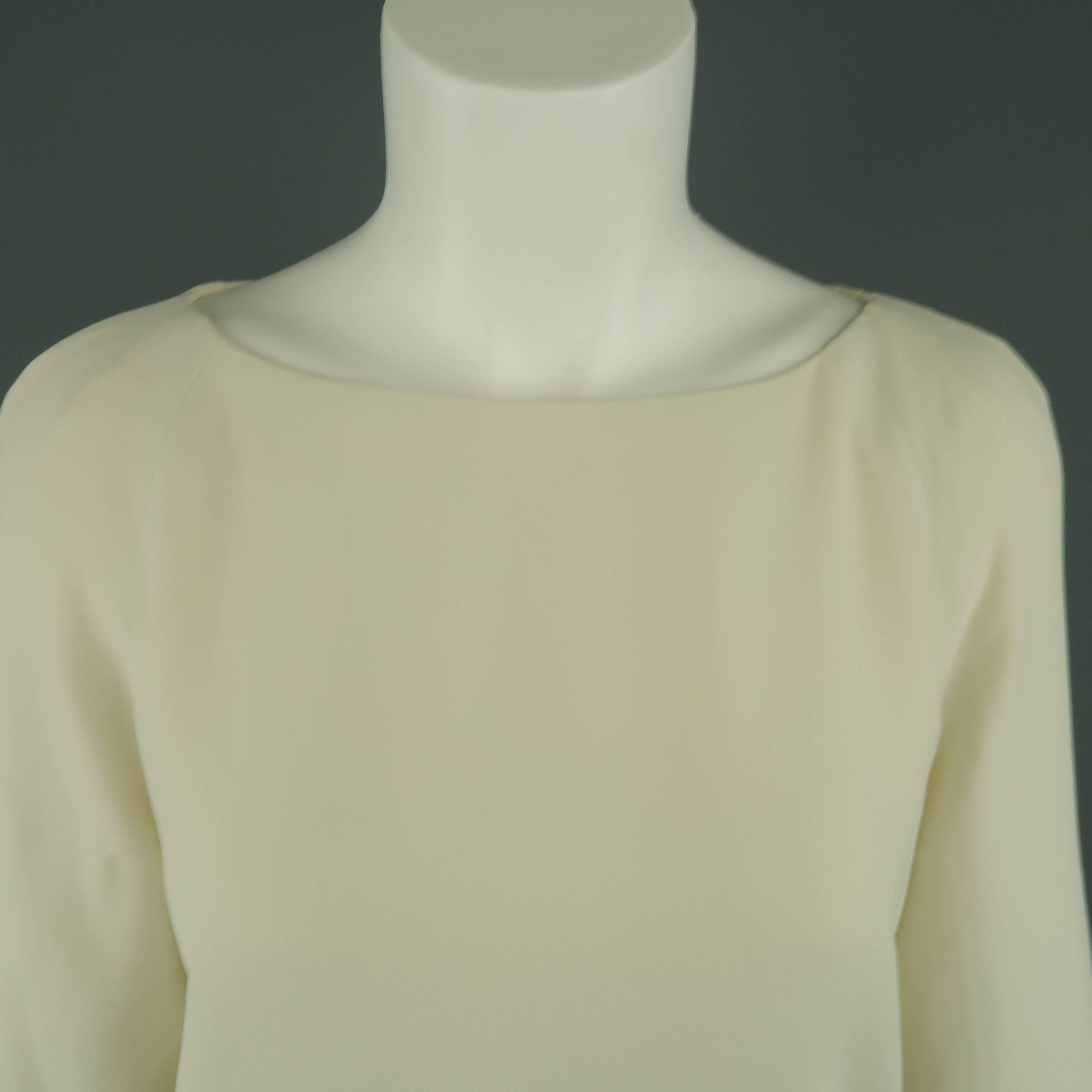 THE ROW blouse comes in creamy beige crepe chiffon with a boat neck, A line silhouette, and bishop sleeves with gold tone button accented cuffs Made in USA.
 
Excellent Pre-Owned Condition.
Marked: 8
 
Measurements:
 
Shoulder: 17 in.
Bust: 40