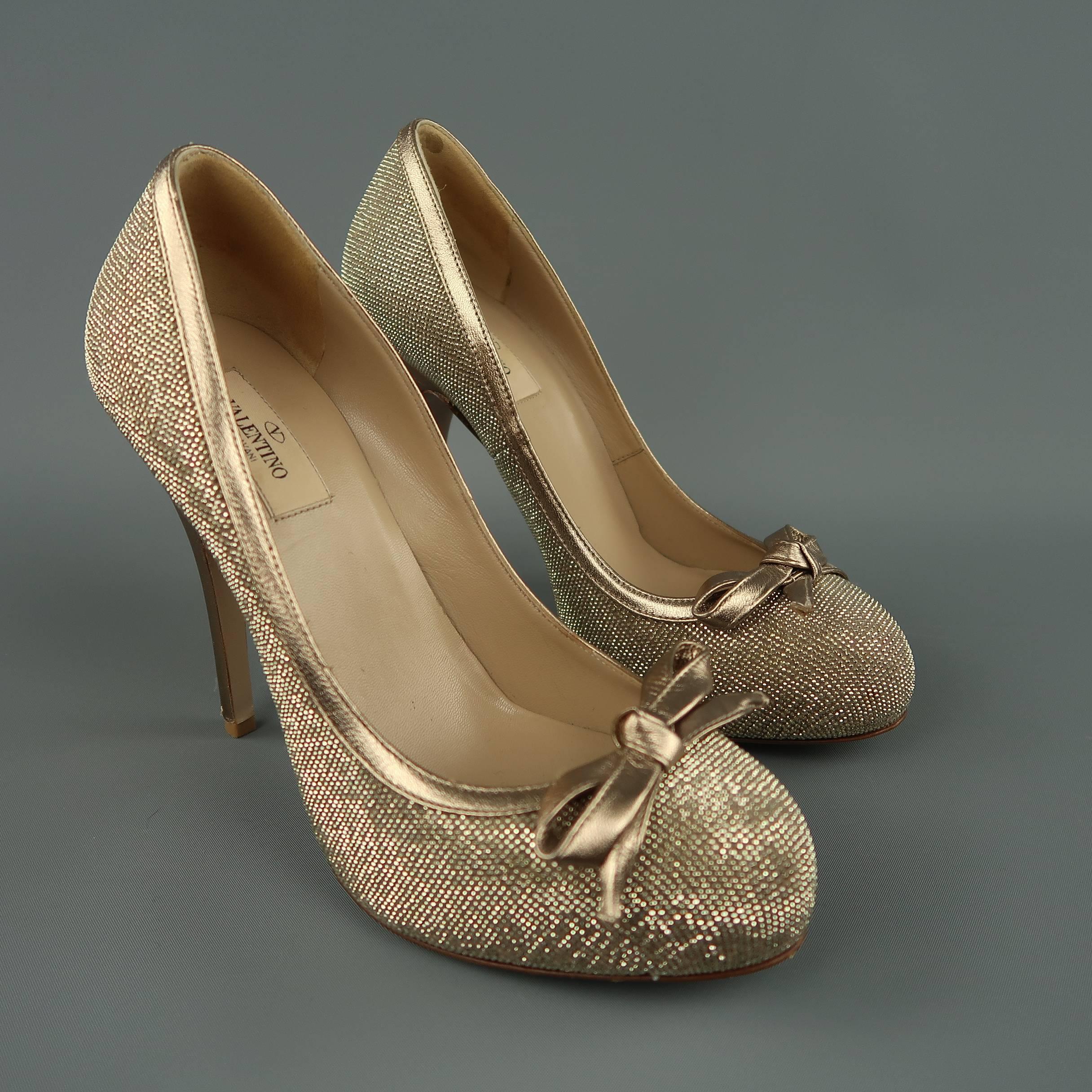 VALENTINO pumps come in metallic gold leather covered in tiny crystals and feature metallic piping and heel, hidden platform, and bow accent. Worn once. Small scuff on heel. Made in Italy.
 
Good Pre-Owned Condition.
Marked: IT 39
 
Heel: 5 in.
