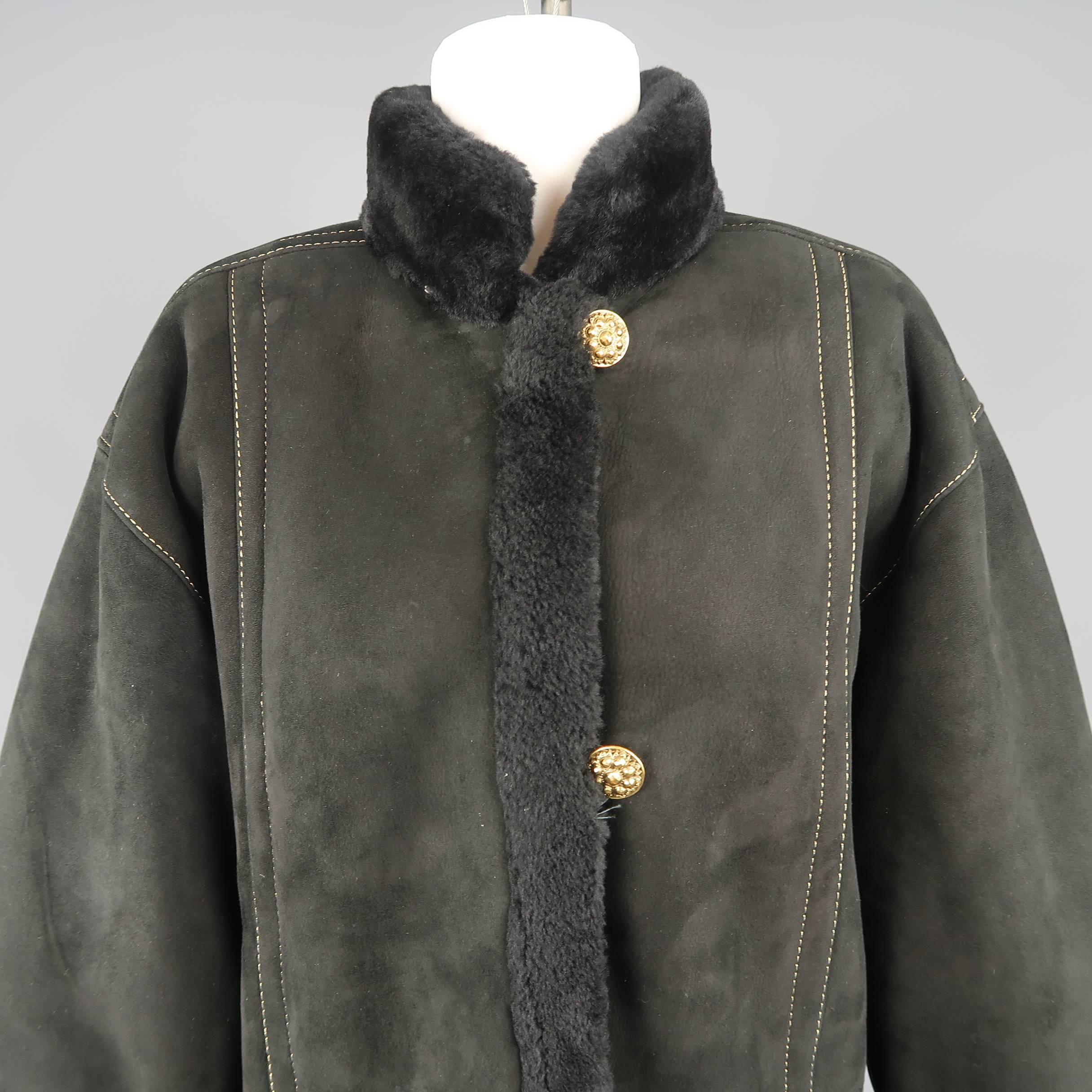 Vintage 1980's YVES SAINT LAURENT Fourrures coat comes black shearling fur lined suede with a high collar, detachable hood, metallic gold contrast stitching, double slit buttoned front, welt pockets, and gold tone engraved buttons. Wear and marks at