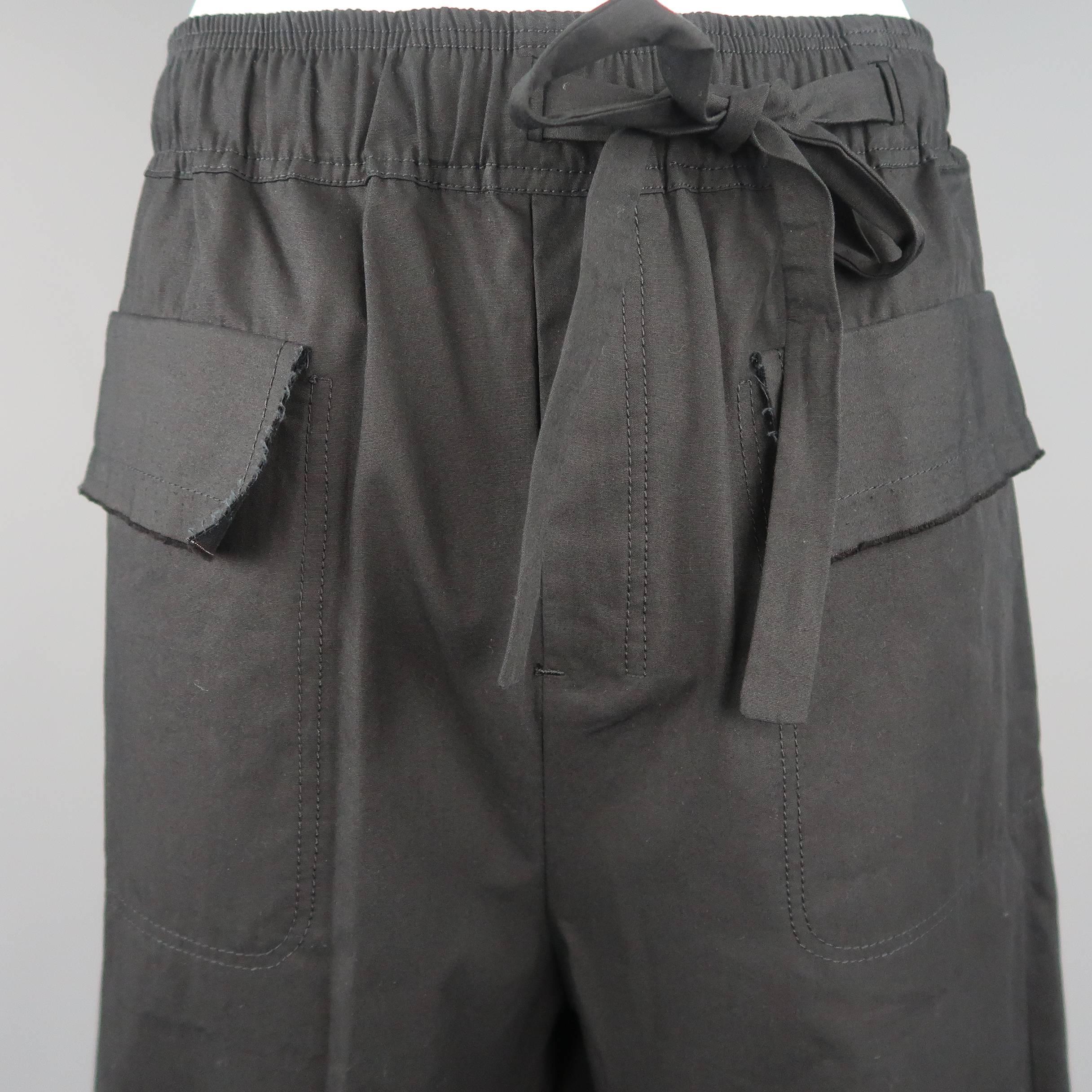 Damir Doma drop crotch shorts come in black cotton canvas with an elastic waistband, asymmetrical tie, and frayed edge flap pockets. Made in Italy.
 
New with Tags.
Marked: L
 
Measurements:
 
Waist: 33 in.
Rise:  20 in.
Inseam: 10 in.
