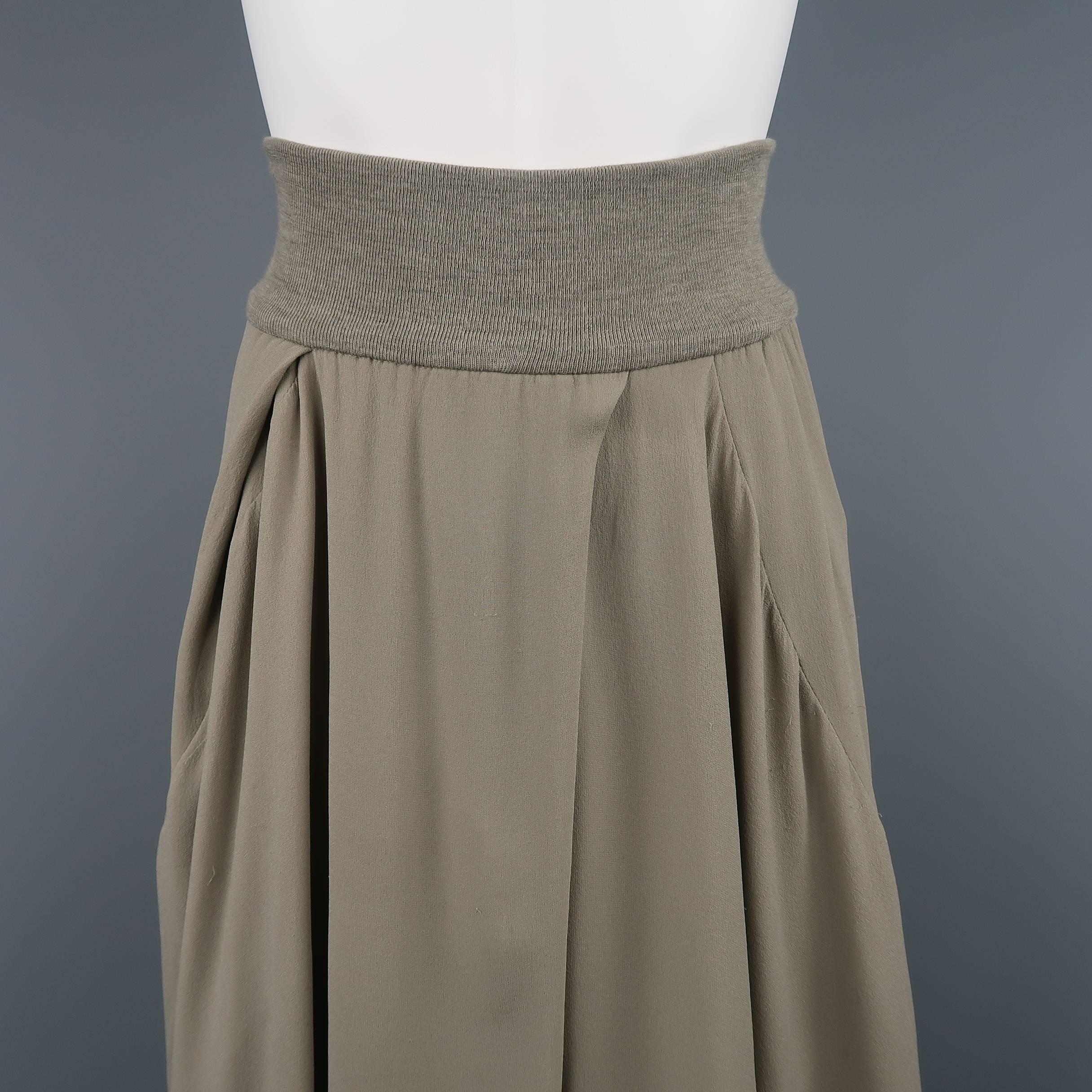 Brunello Cucinelli skirt comes in moss gray silk chiffon with a ribbed knit waistband, layered drape A line silhouette, and high low hem. Wear throughout. As-is. Made in Italy. 
Retails $1995.00
 
Good-Fair Pre-Owned Condition.
Marked: 2
