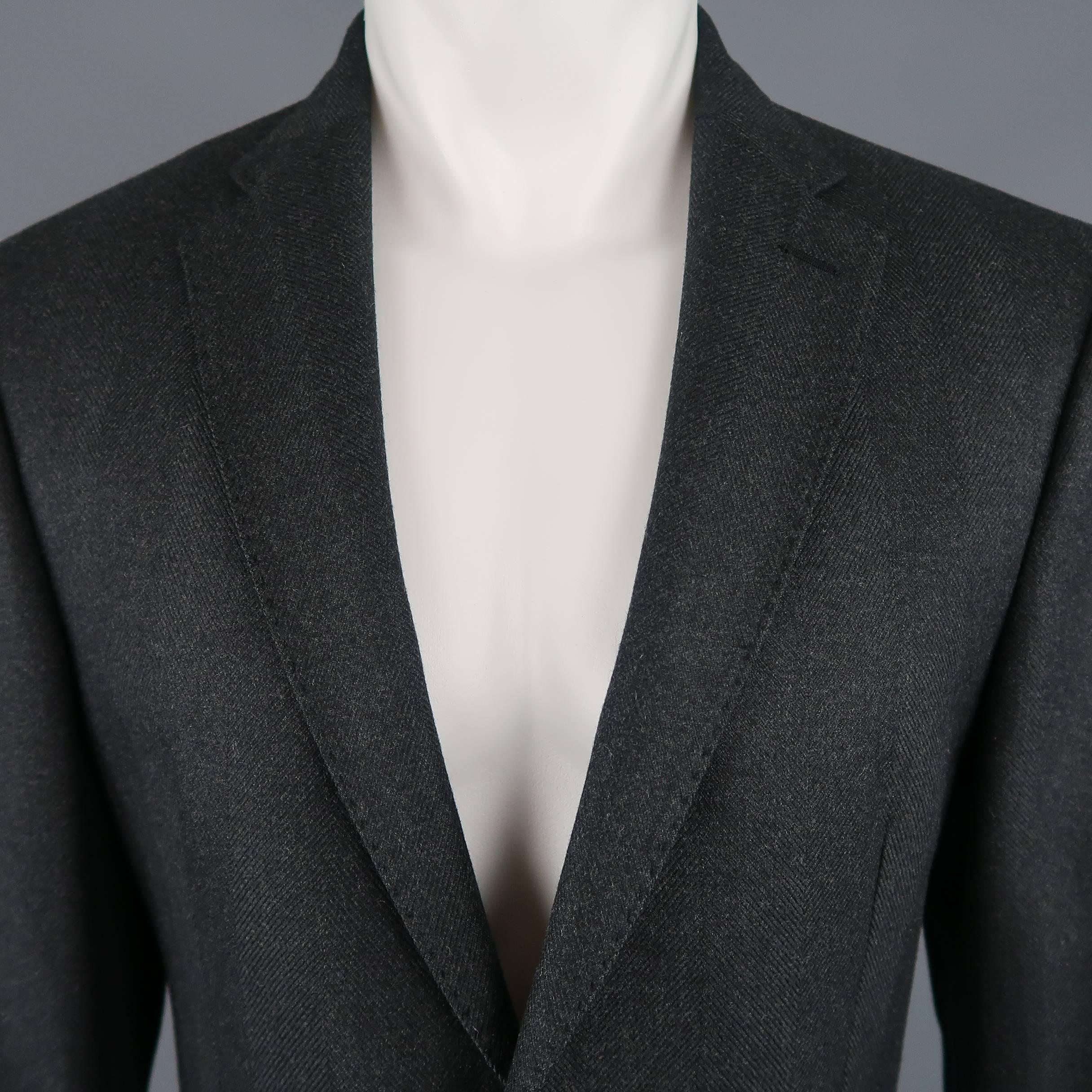 Raf Simons sport coat comes in heavy charcoal herringbone textured wool with a top stitch notch lapel, two button front, functional button cuff, and flap details. Made in Italy.
 
Excellent Pre-Owned Condition.
Marked: IT 50
 
Measurements:
