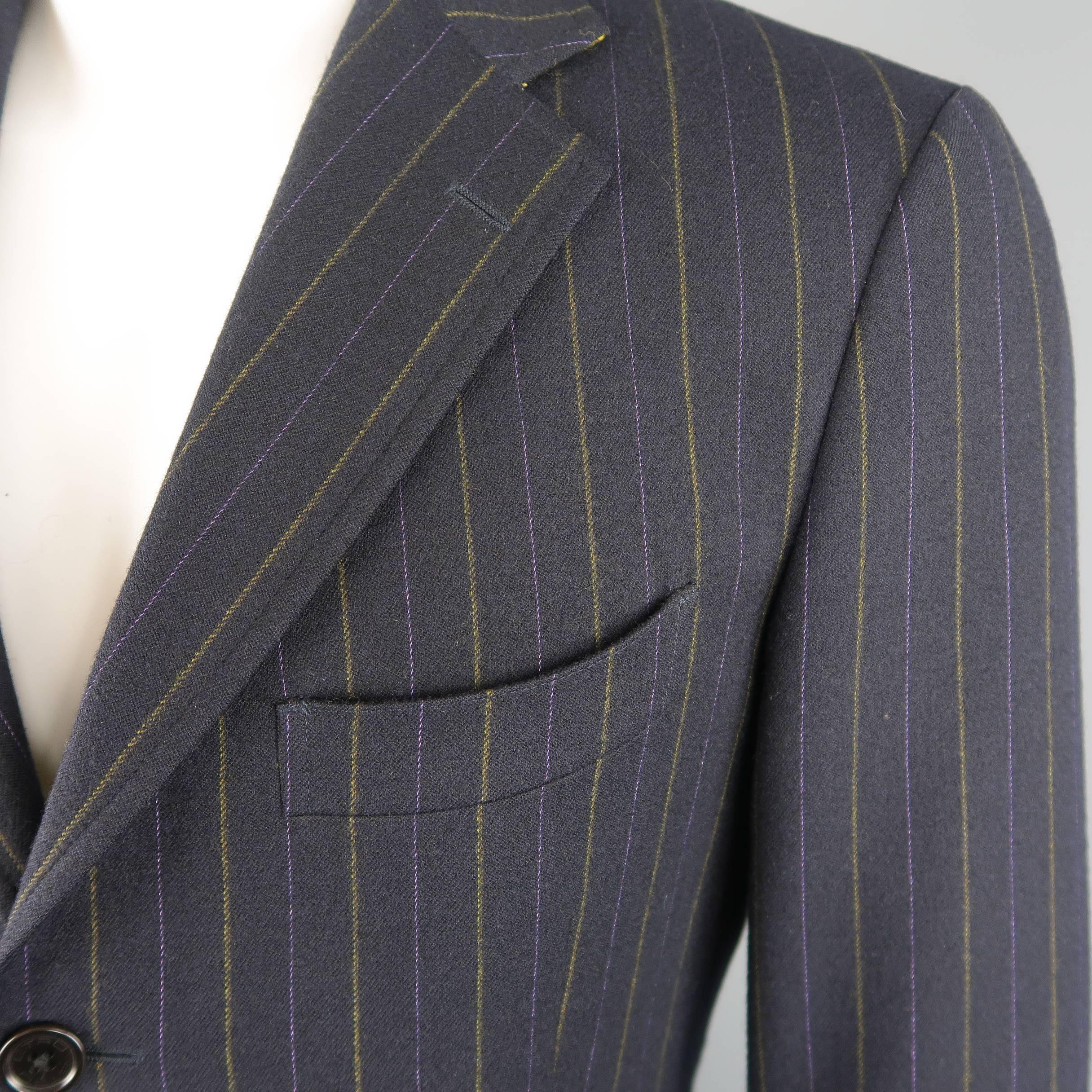 Single breasted ETRO sport coat comes in navy blue wool with purple and yellow pinstripe pattern, notch lapel, three button front, triple flap pockets, and yellow collar liner. Made in Italy.
 
Excellent Pre-Owned Condition.
Marked: IT 50
