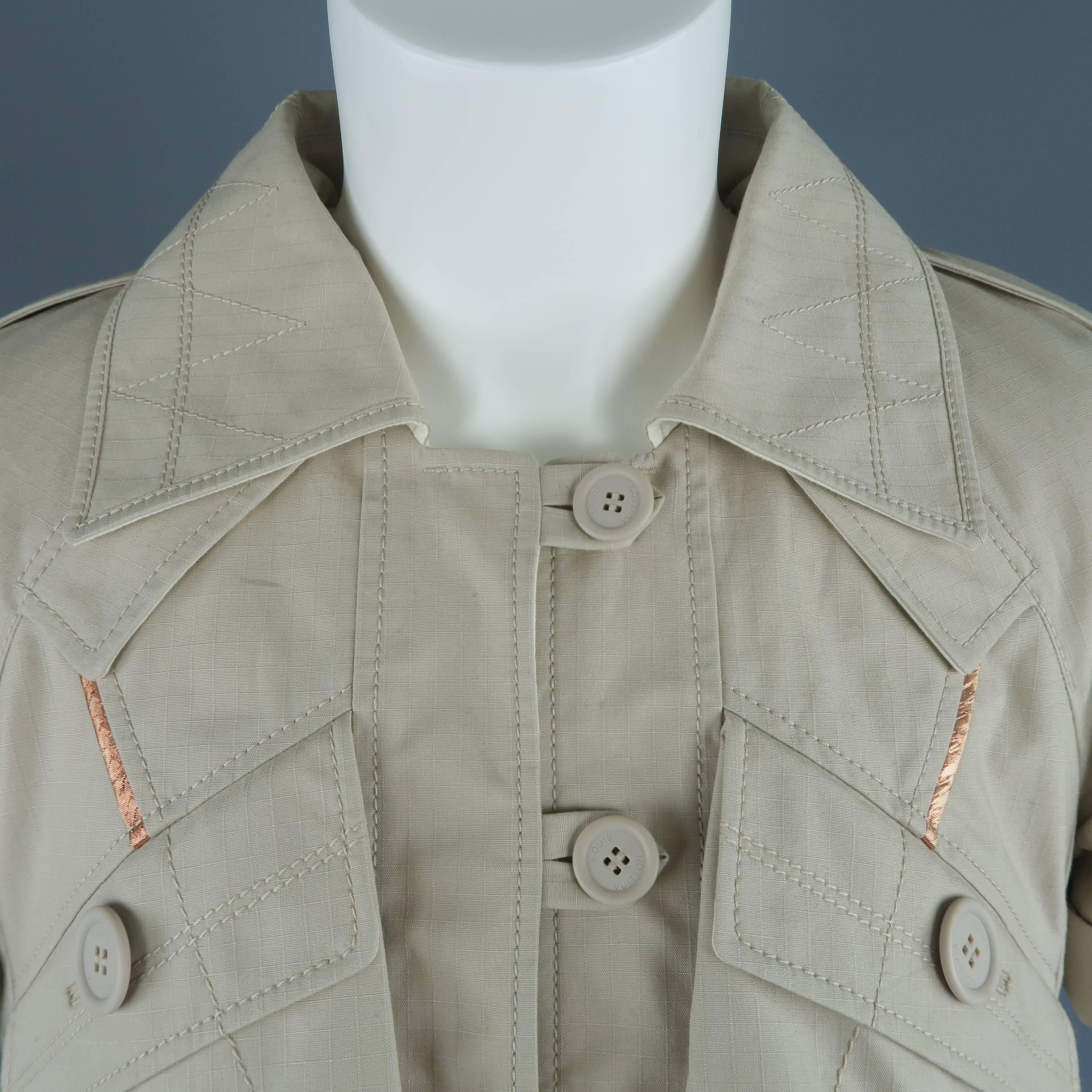 Louis Vuitton jacket comes in beige cotton blend textured canvas with a pointed collar, three button front, slanted patch flap pockets, short, cuffed sleeves, cropped A line ruffle silhouette, and metallic copper piping. Stains and wear throughout.