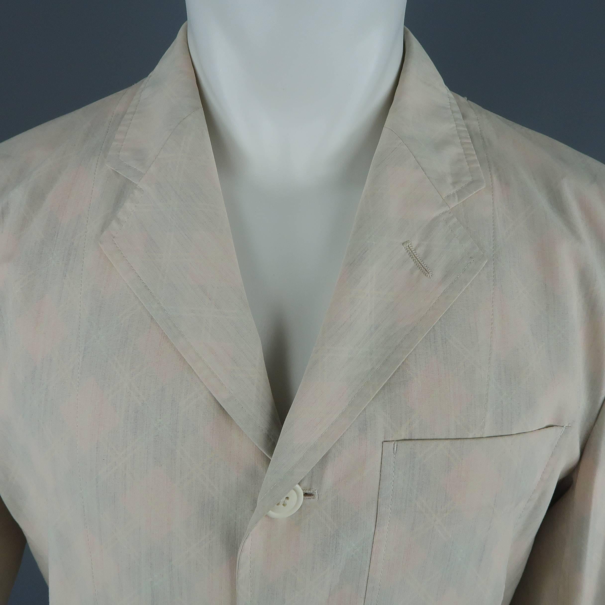 Issey Miyake Vintage single breasted sport coat comes in beige fabric with internal red argyle print faintly showing through to the exterior and features a notch lapel, three button front, and patch flap pockets. Made in Japan.
 
Good Pre-Owned