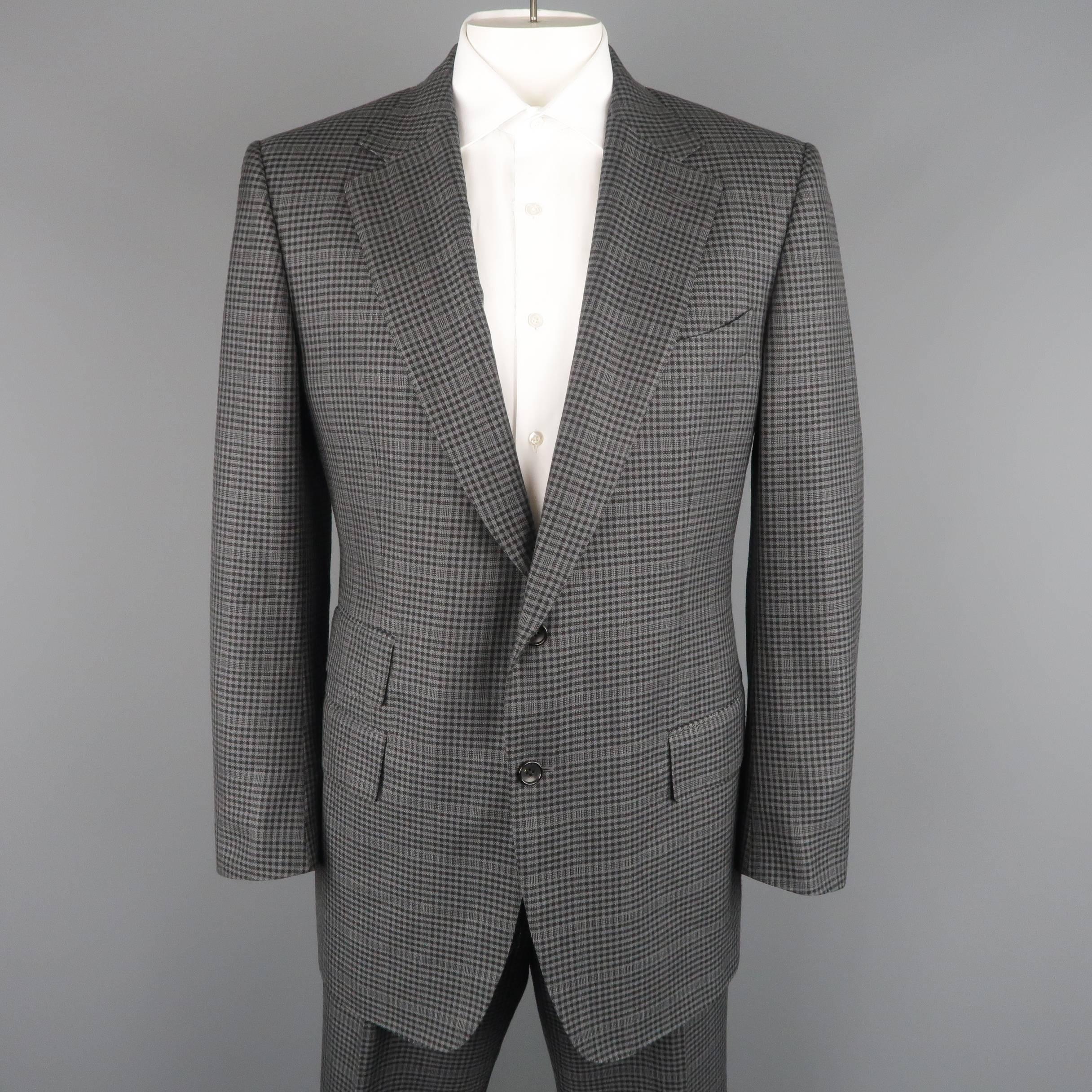 Two piece TOM FORD suit comes in dark gray and black plaid silk wool blend fabric and includes a single breasted, two button, notch lapel jacket with triple flap pockets, and functional button cuffs with matching cuffed, flat front trousers. Made in