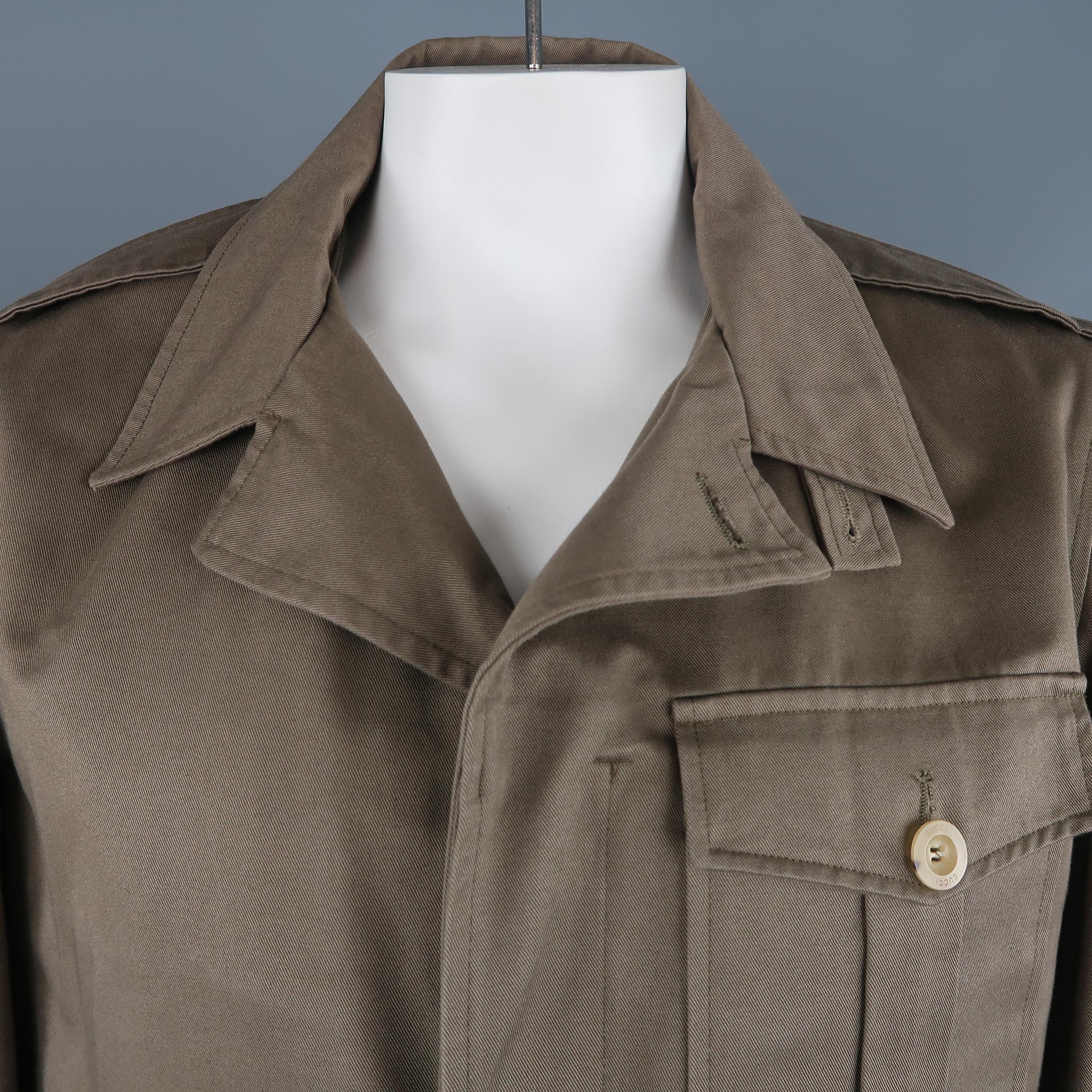 GUCCI by TOM FORD army style jacket comes in olive green cotton twill with a pointed lapel, hidden placket zip and button front, epaulets, side tabs, and patch flap pocket. Wear and marks throughout. As-is. Made in Italy.
 
Fair Pre-Owned
