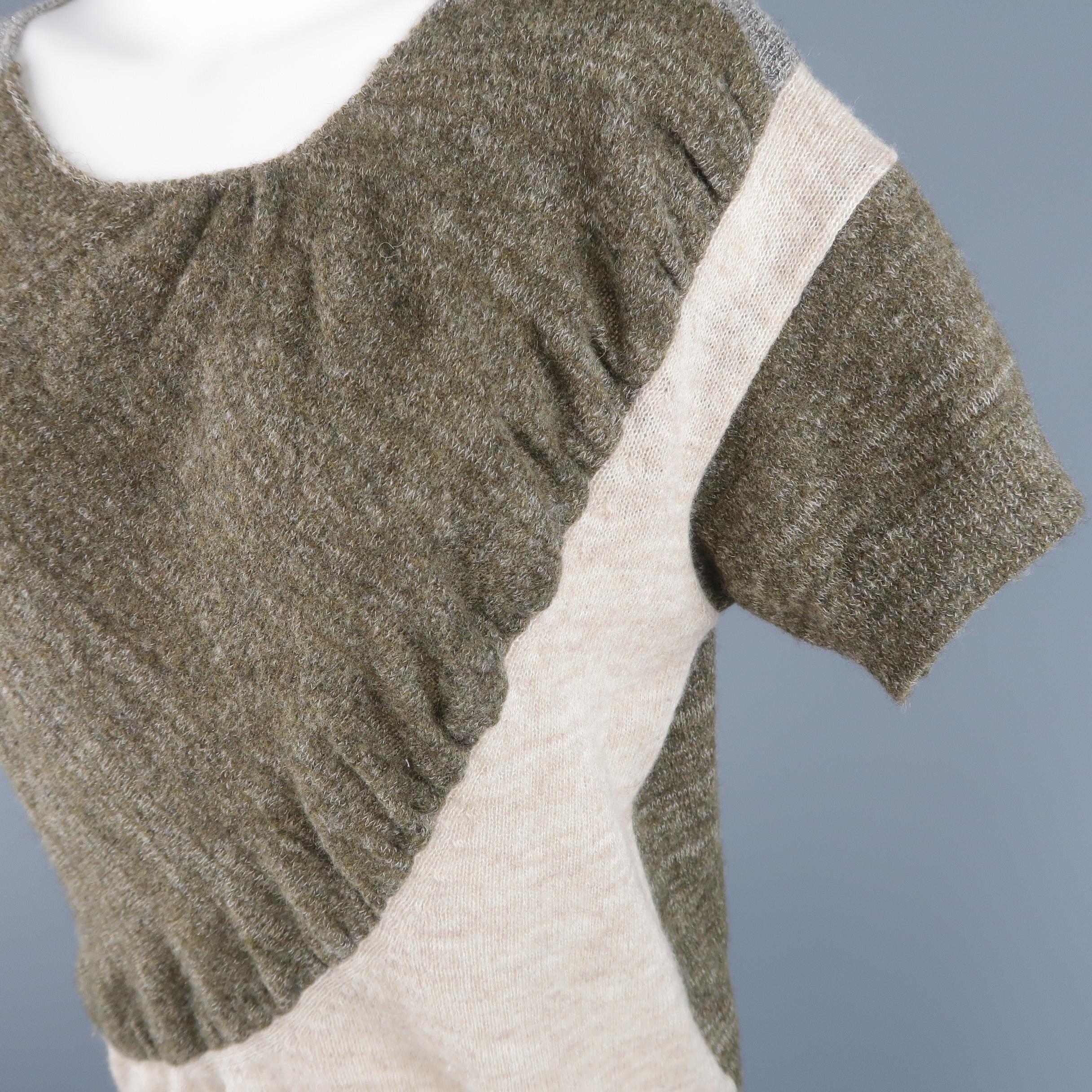 DRIES VAN NOTEN pullover features panels of heathered olive green, beige, and silver metallic wool blend knit. Made in Belgium.
 
Excellent Pre-Owned Condition.
Marked: Small
 
Measurements:
 
Shoulder: 16 in.
Bust: 42 in.
Sleeve: 7 in.
Length: 24