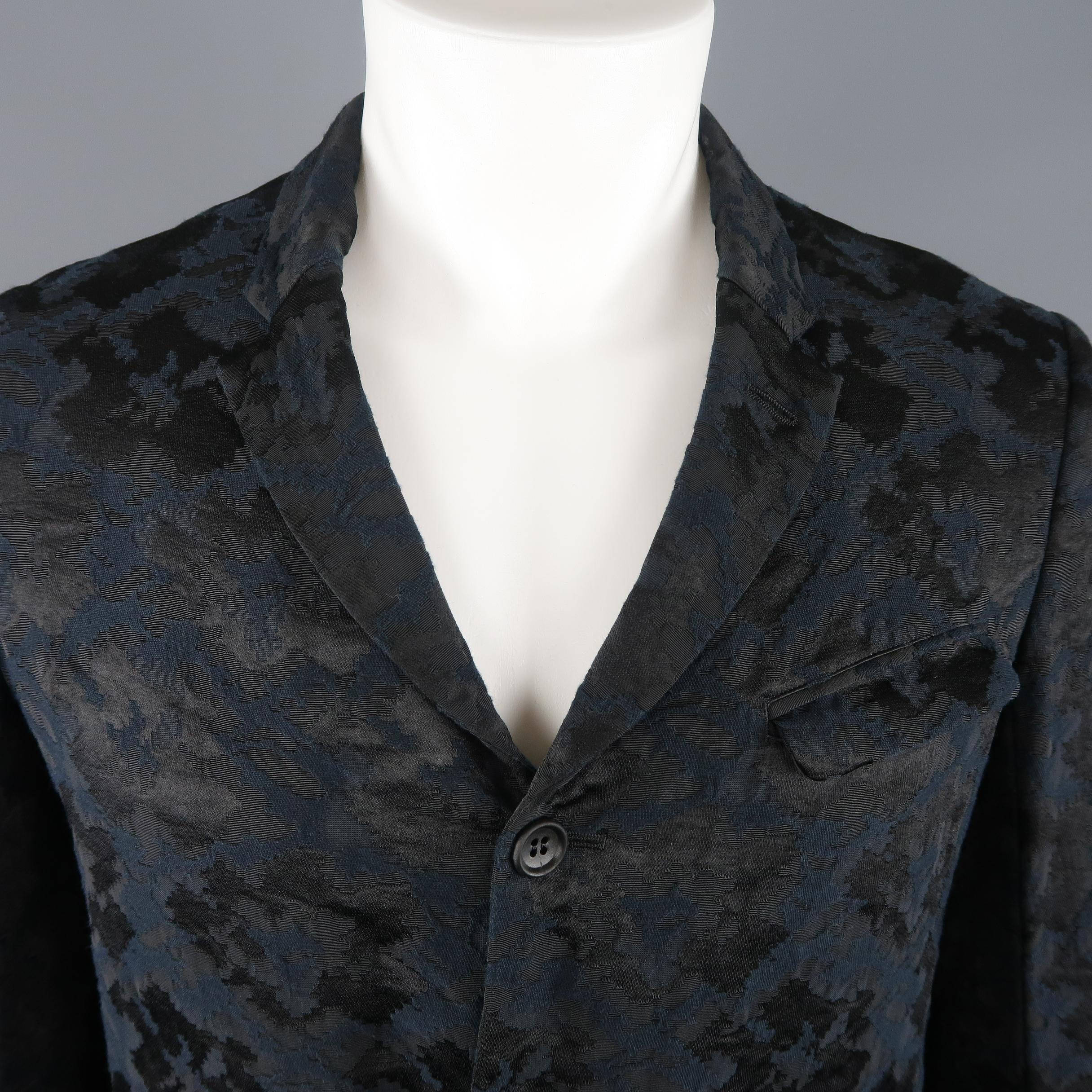 COMME des GARCONS HOMME PLUS sport coat comes in black and midnight navy blue jacquard fabric with a skinny pointed lapel, three button front, and rolled cuffs. Made in Japan.
 
Good Pre-Owned Condition.
Marked: M (AD 2011)
 
Measurements:
