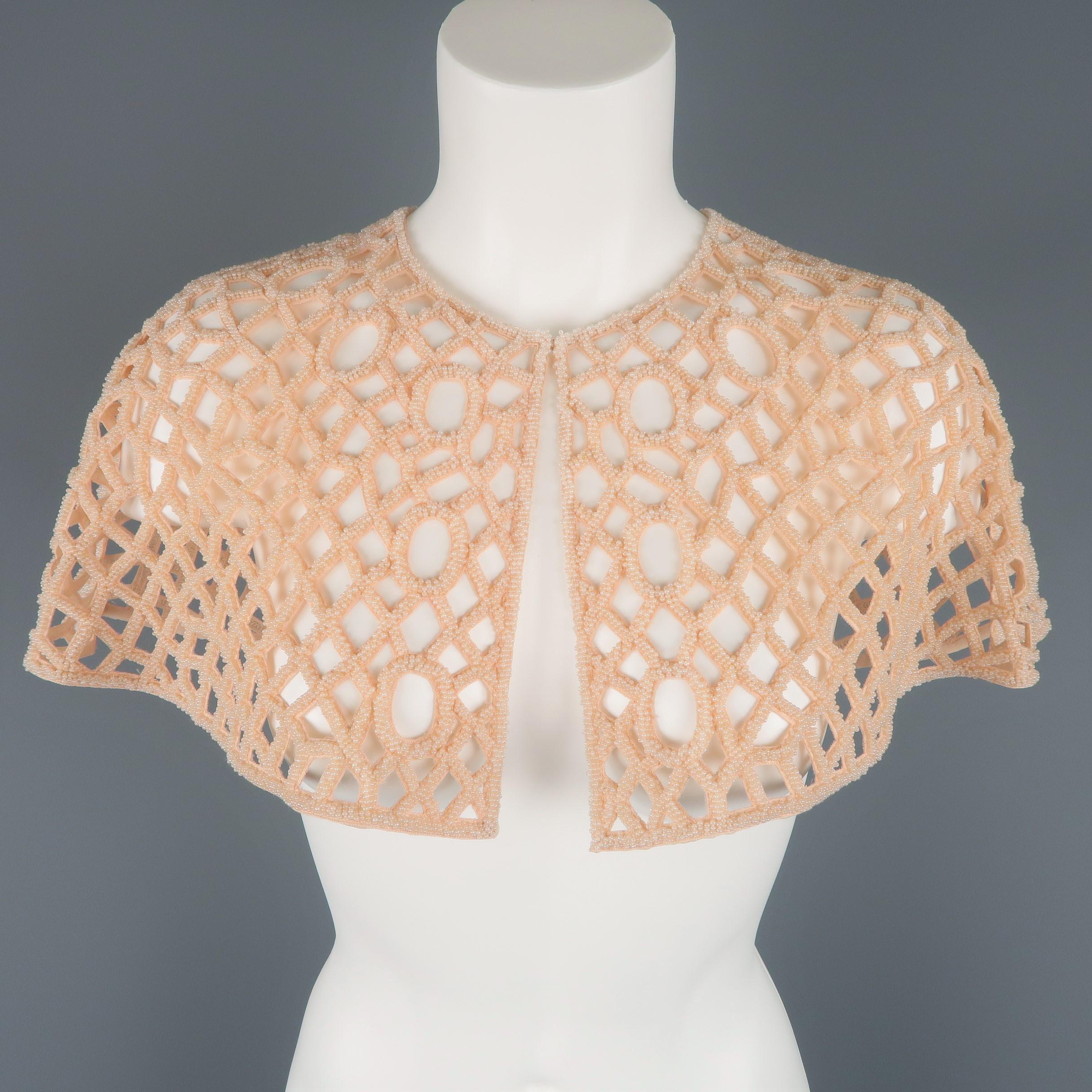 Joanna Mastroianni capelet comes in light salmon pink geometric cutout mesh fabric with beadwork throughout and hook eye closure. Made in USA.  Retailed: $1800.00
Very Good Pre-Owned Condition.
 
Measurements:
Length: 10 in.
Width: 25 in.